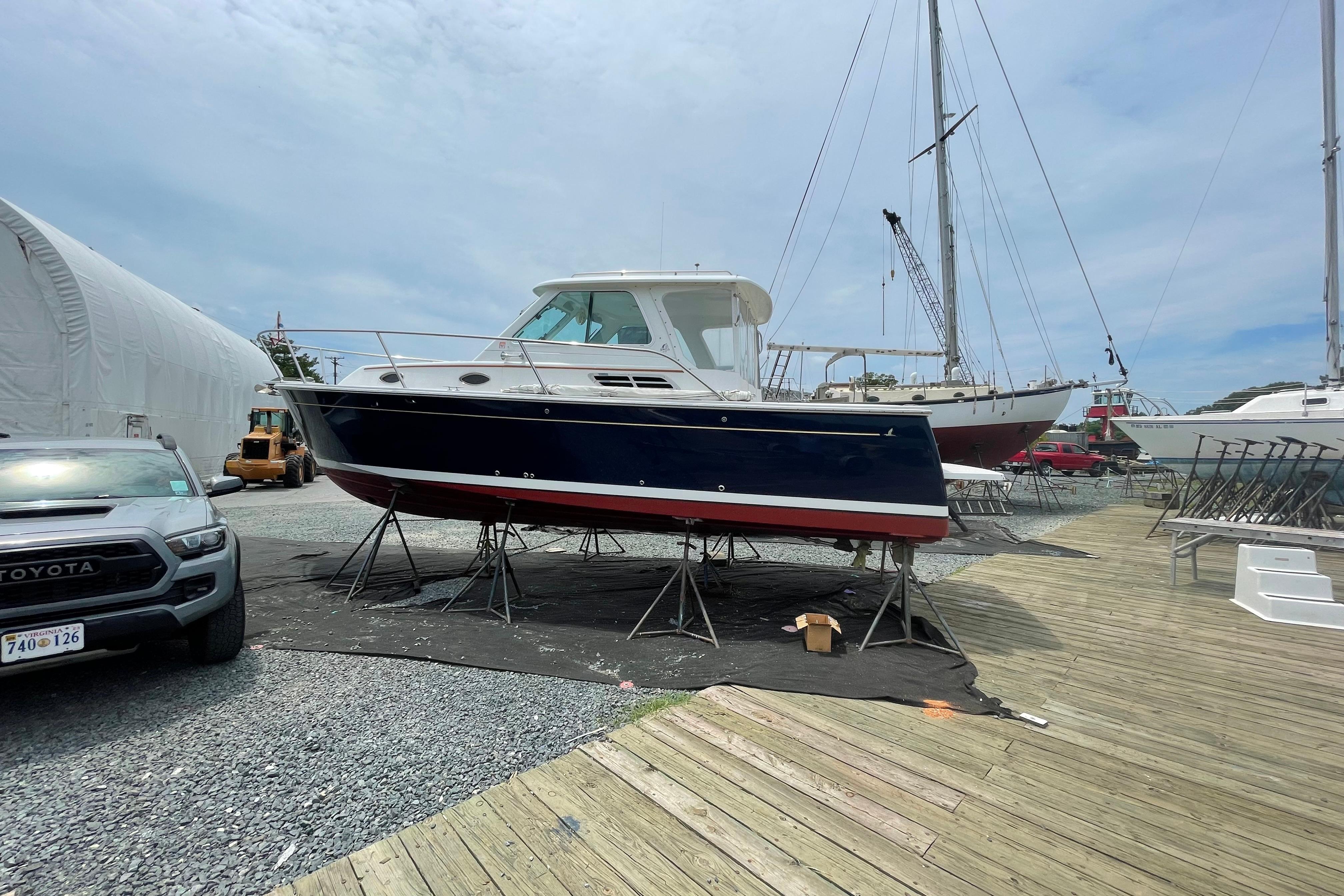 2007 Back Cove 29 boat on stands in a marina, surrounded by other vessels.