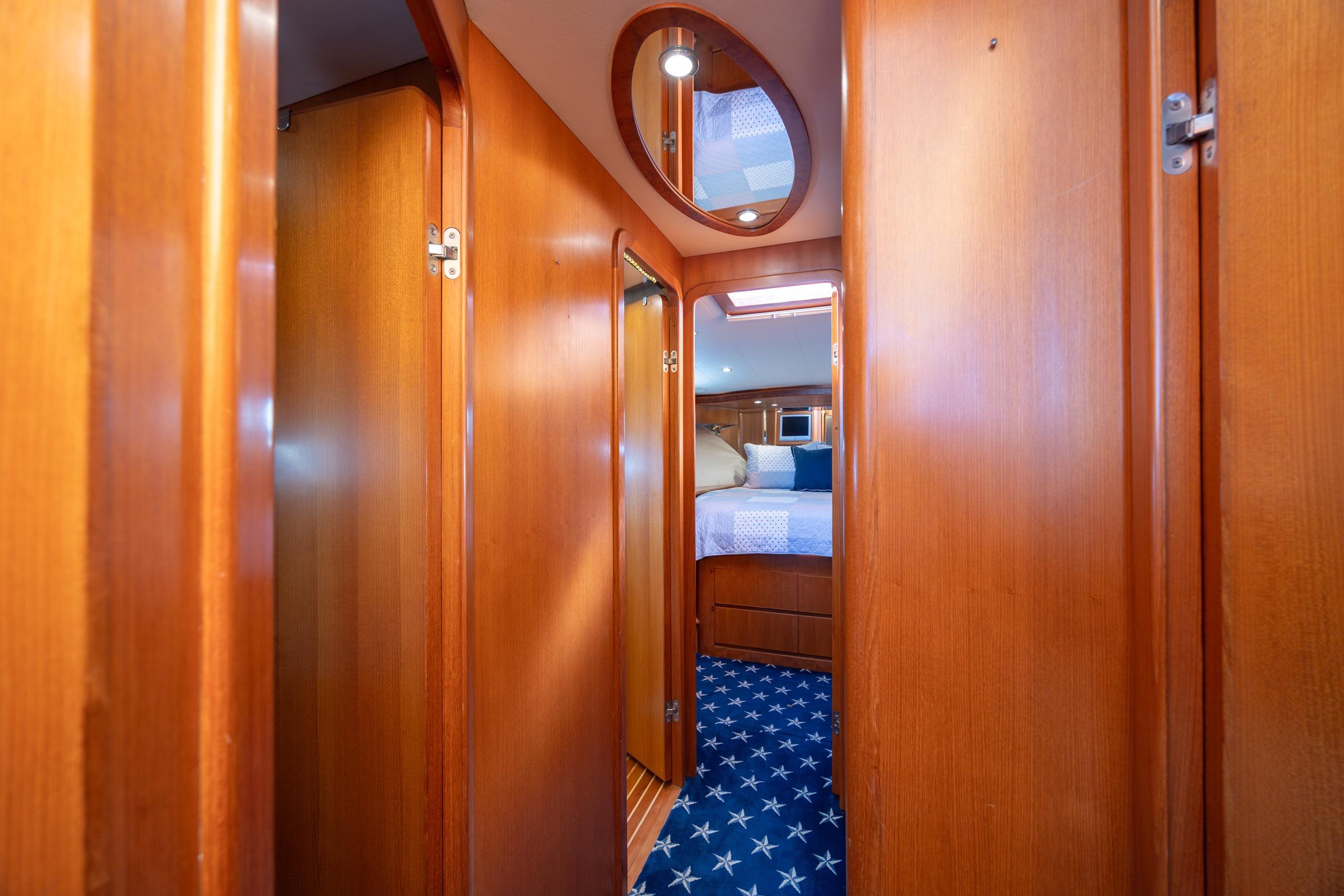 Interior hallway of 2005 Ocean Alexander 52 Sedan yacht with wooden paneling and star-patterned carpet.