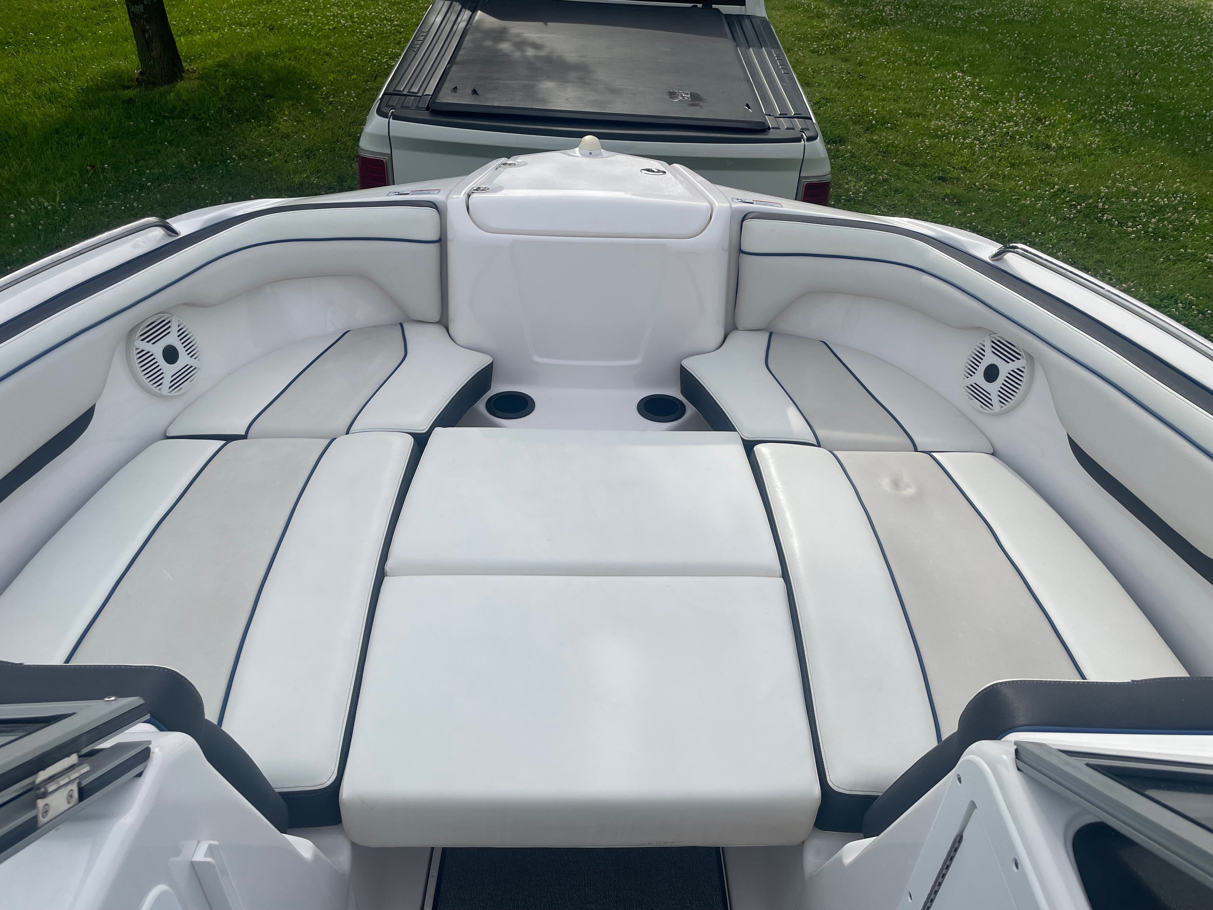 The image shows the spacious cockpit of a 2019 Yamaha SX210 boat with white upholstery.