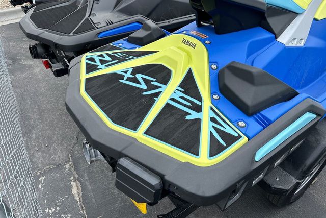 Close-up of a blue and yellow Yamaha WaveRunner jet ski on a parking lot.