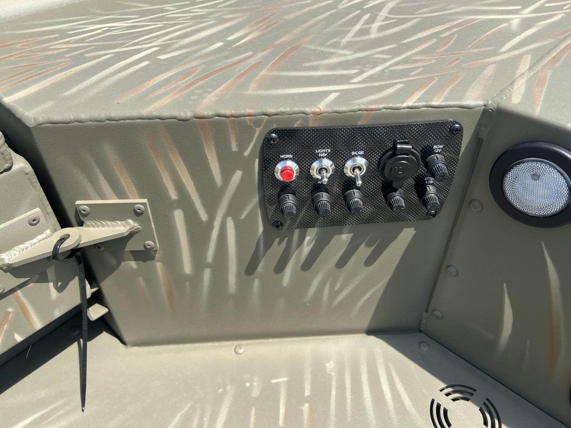 Control panel of 2025 Tracker Grizzly 1654 T Sportsman boat with switches and outlets.