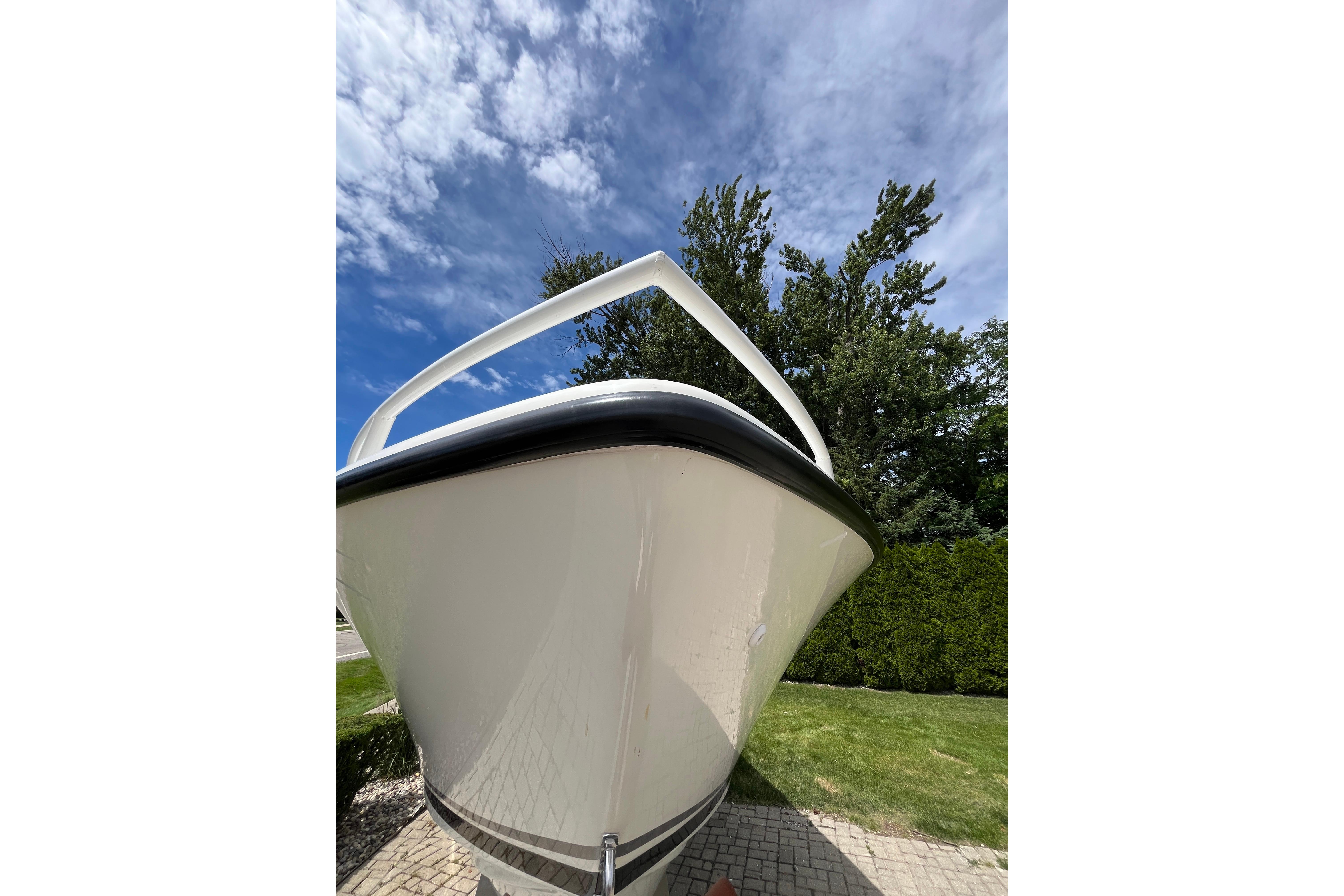 1994 Intrepid 30 Open Cuddy boat, bow view, against a blue sky and trees.
