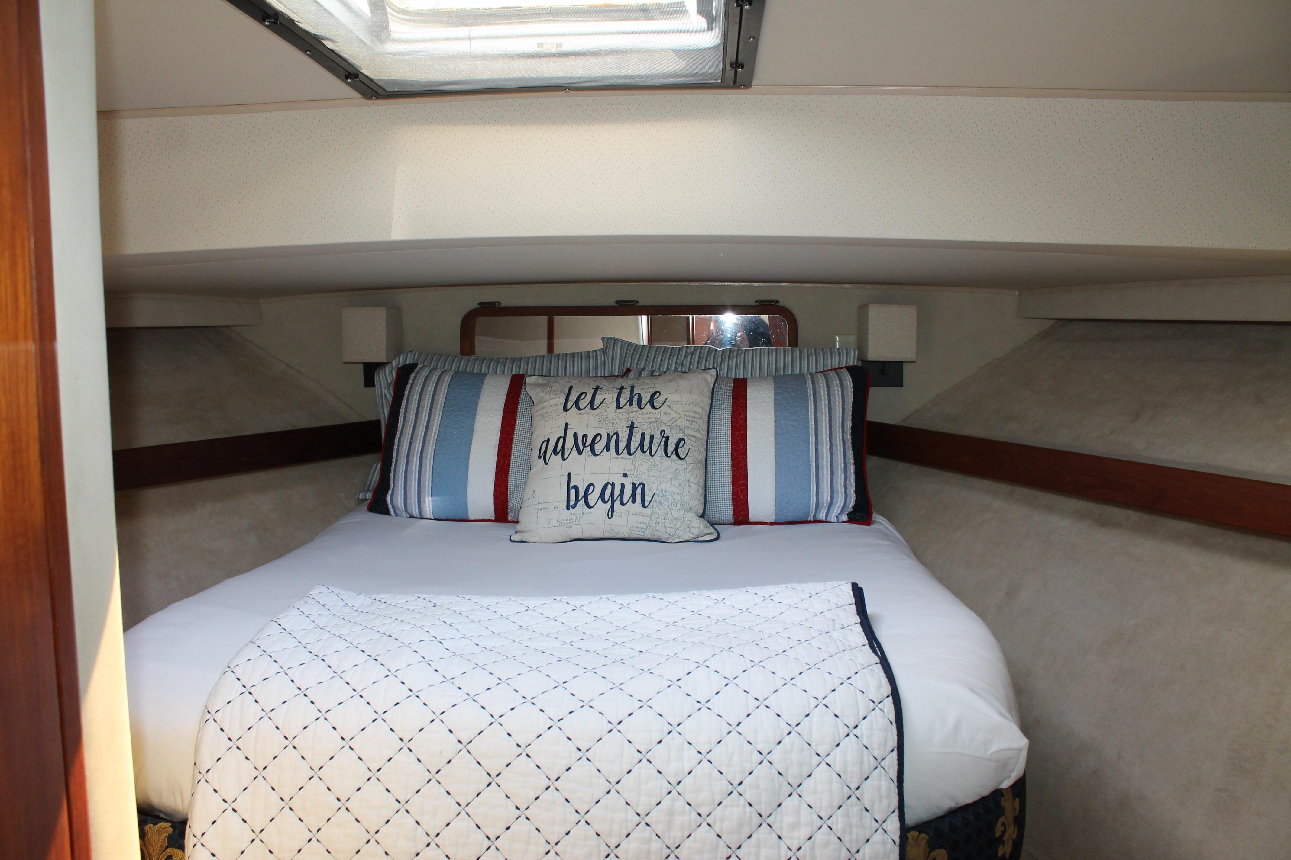 Cozy bedroom in 1987 Chris-Craft 427 Catalina yacht with nautical-themed bedding.