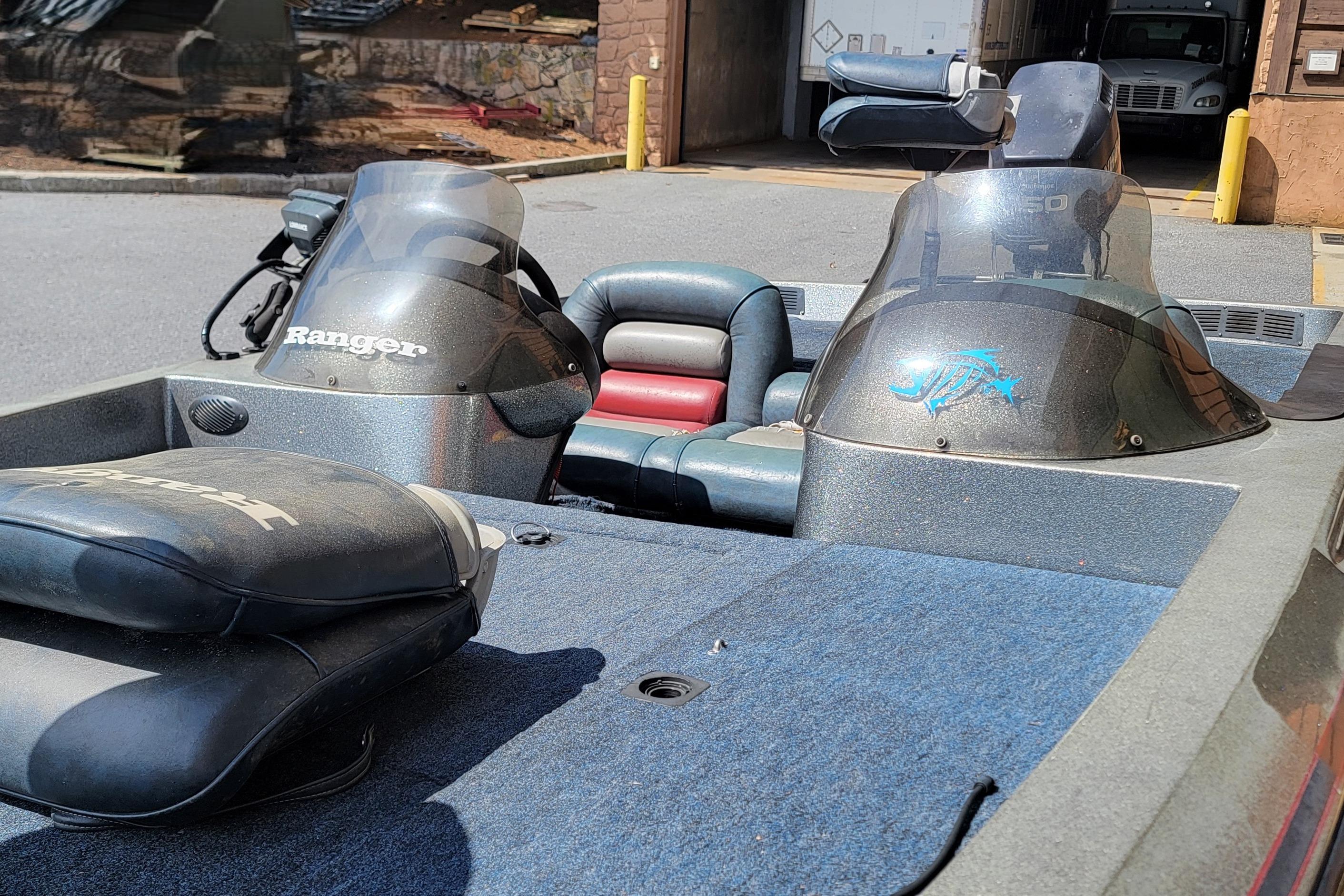 1995 Ranger boat interior with dual consoles and cushioned seating, parked outdoors.