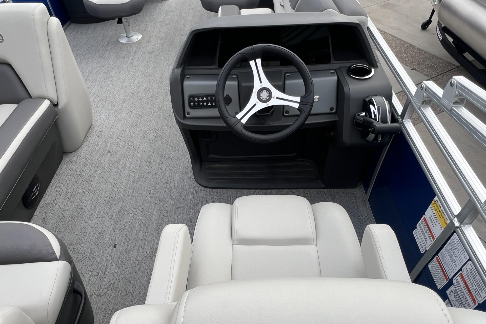 2026 Sun Tracker Fishin' Barge 20 DLX interior with steering console and seating.