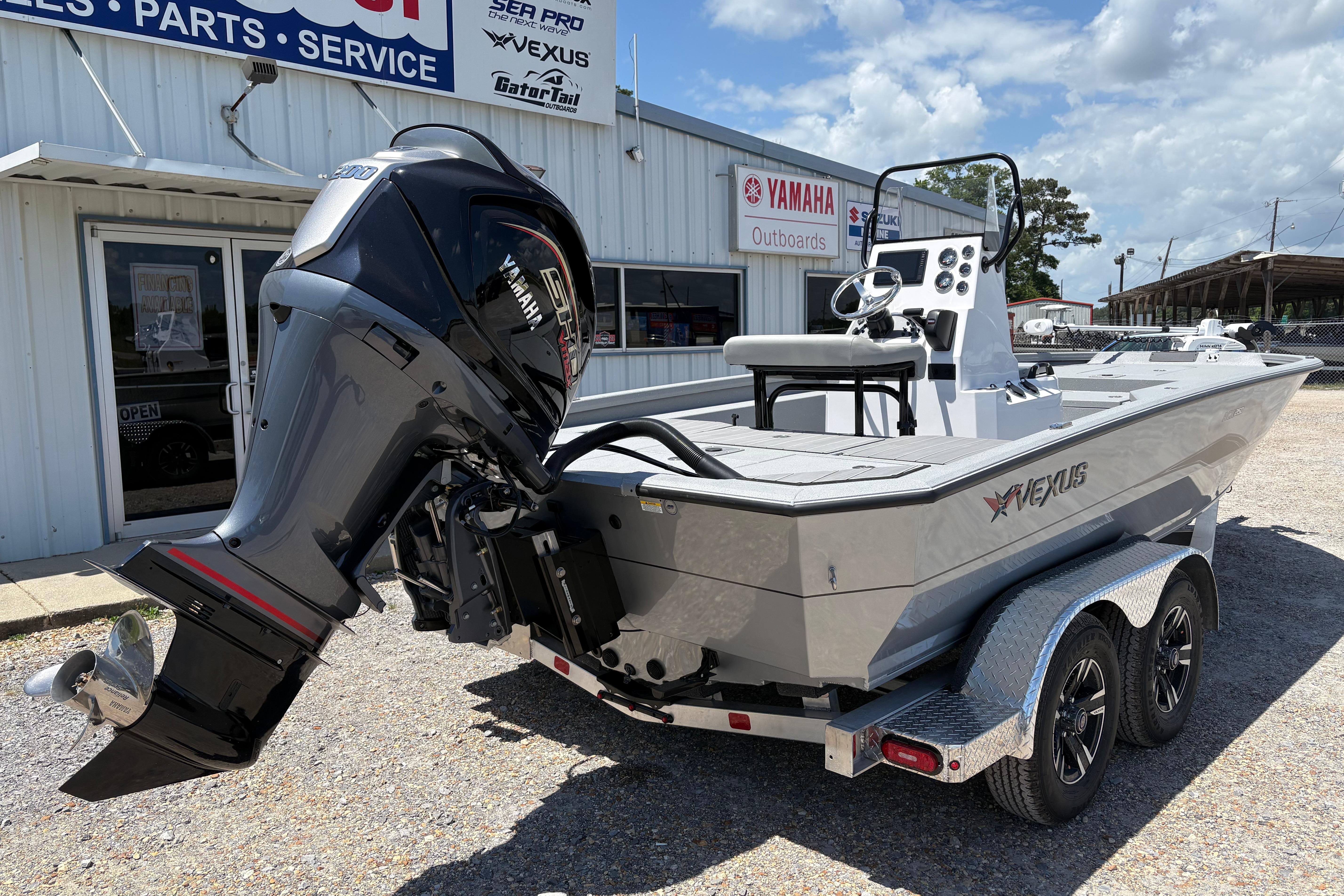 2026 Vexus ACX 2150 boat with Yamaha outboard motor, parked outside dealership.