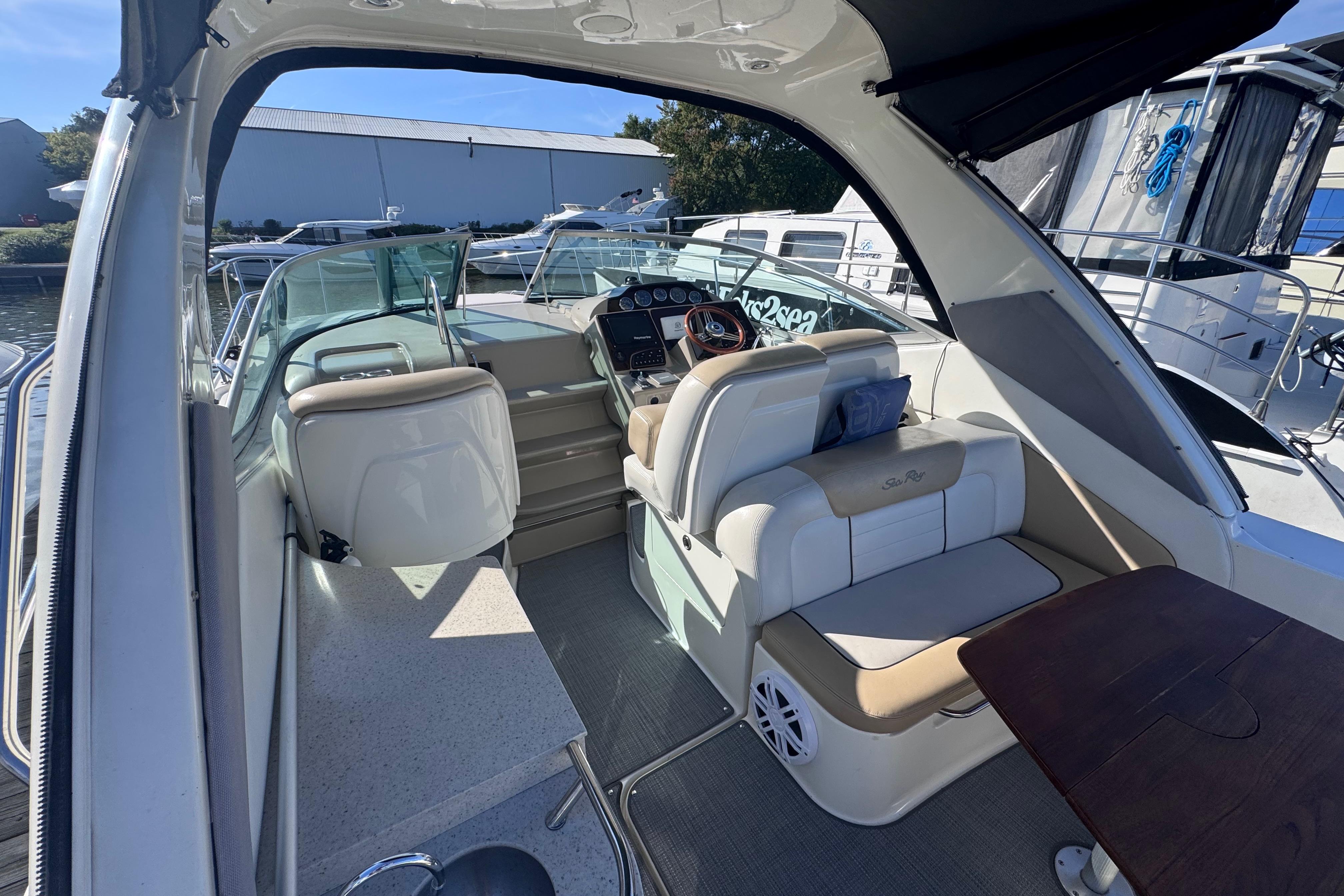 2008 Sea Ray 350 Sundancer cockpit with seating, helm, and table, docked at marina.