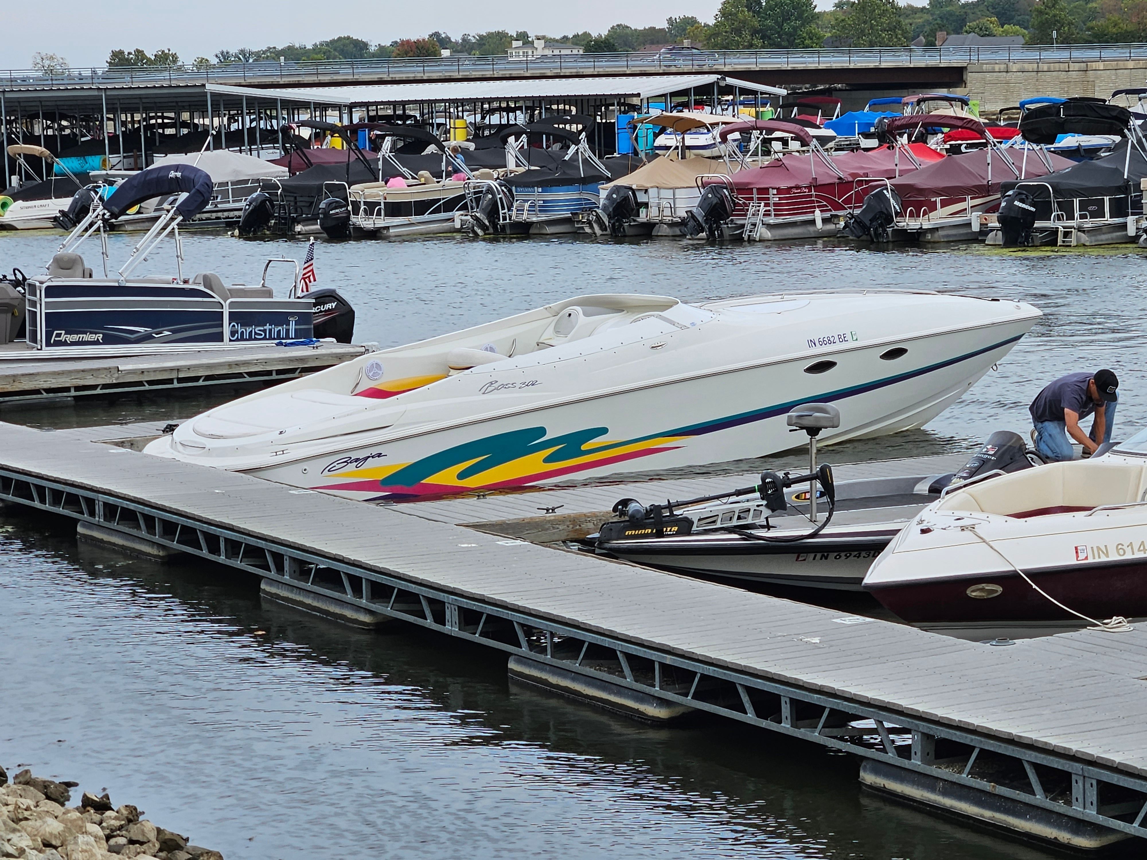 A 1996 Baja 302 Boss docked, surrounded by other boats.