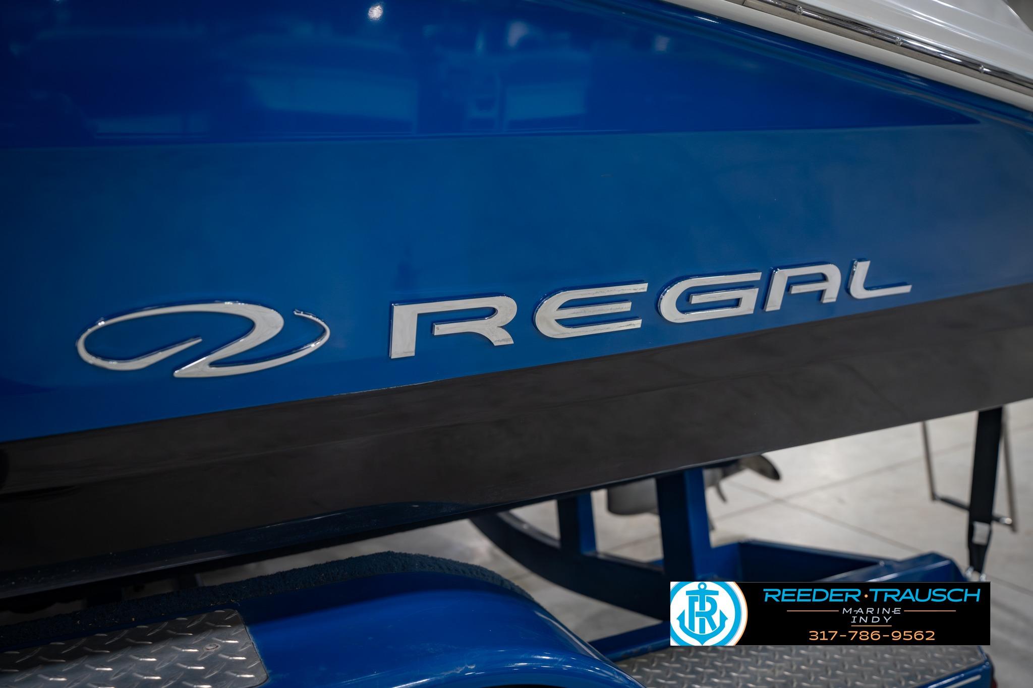 2015 Regal 2000 ESX Bowrider boat, blue hull with logo, displayed indoors.