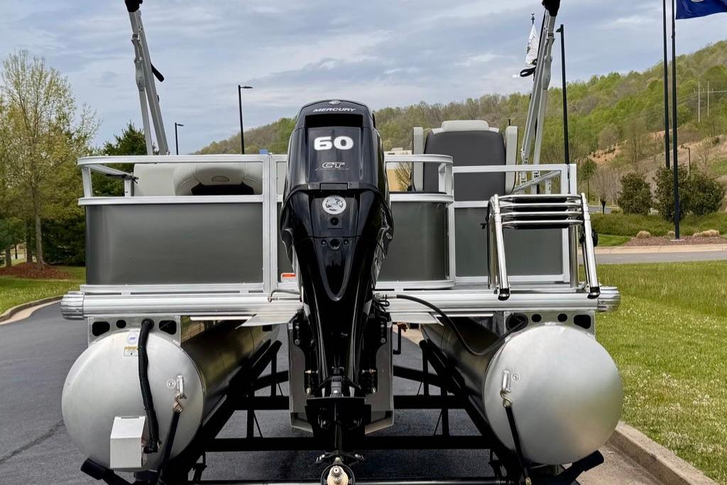 2026 Sun Tracker Bass Buggy 18 DLX pontoon boat with Mercury 60 GT engine, parked outdoors.