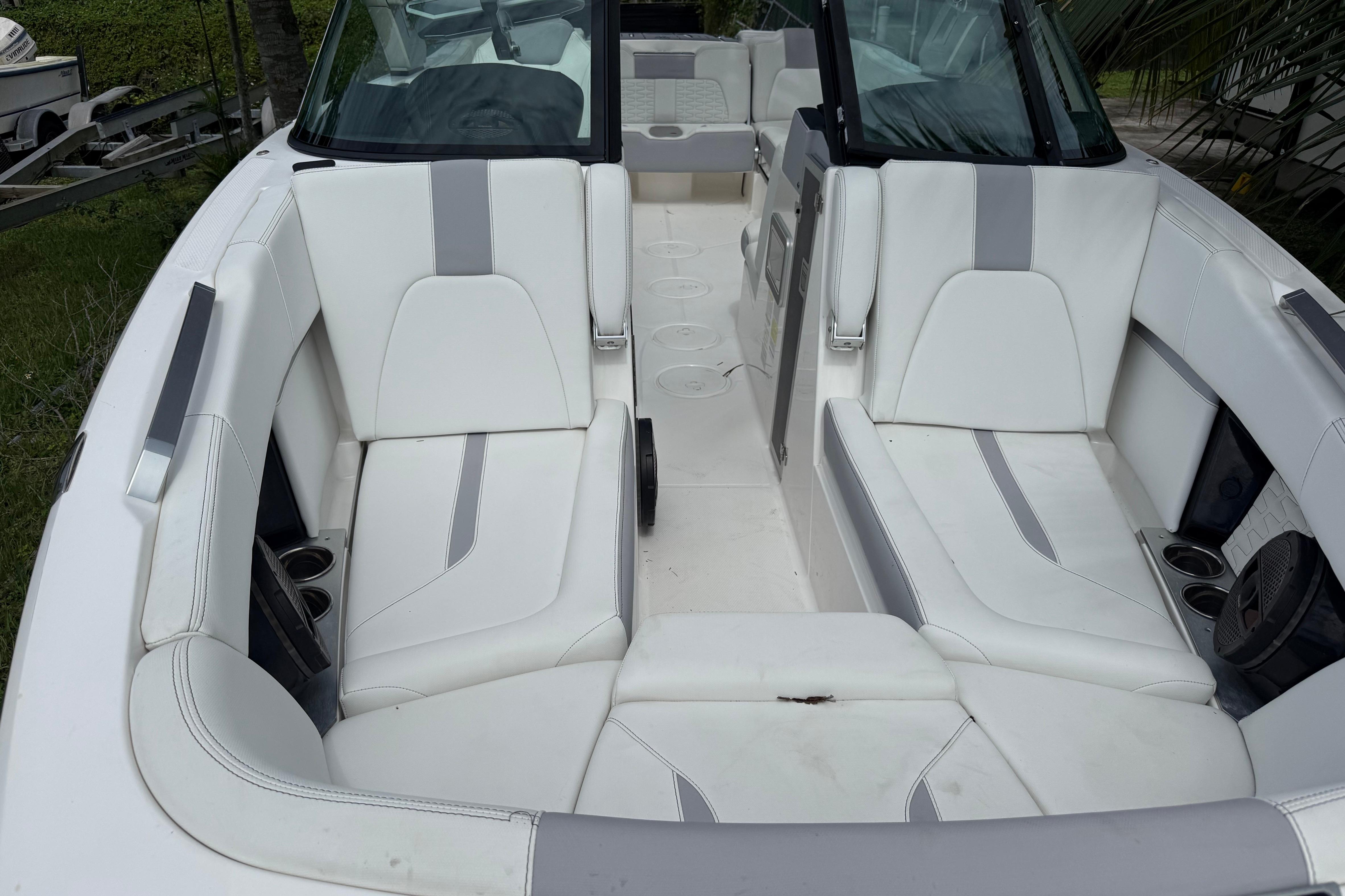 2023 MasterCraft X24 boat interior with white and gray seating, cup holders, and sleek design.
