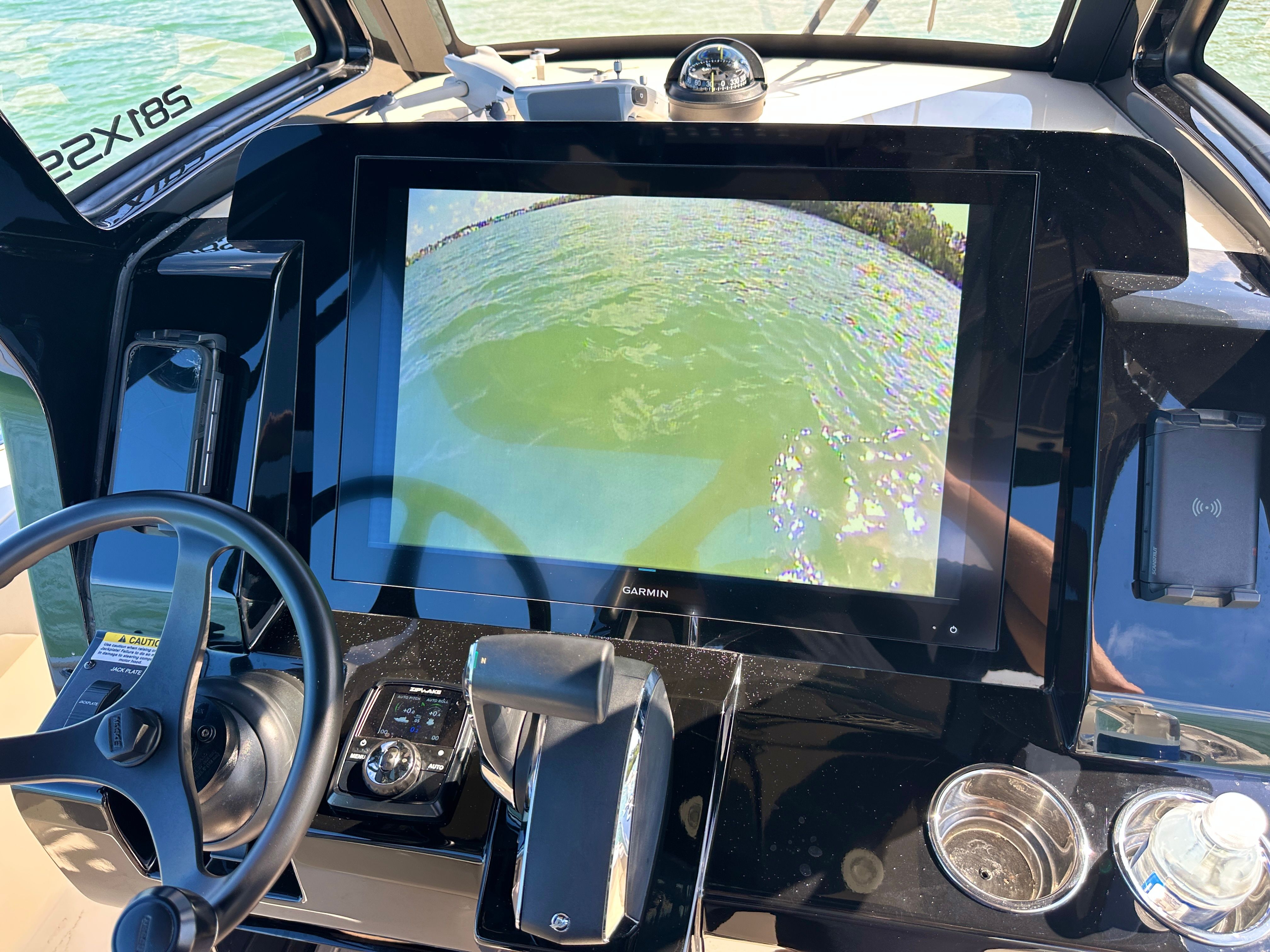 The image shows the cockpit of a Scout 281 XSS boat with a large screen and controls.