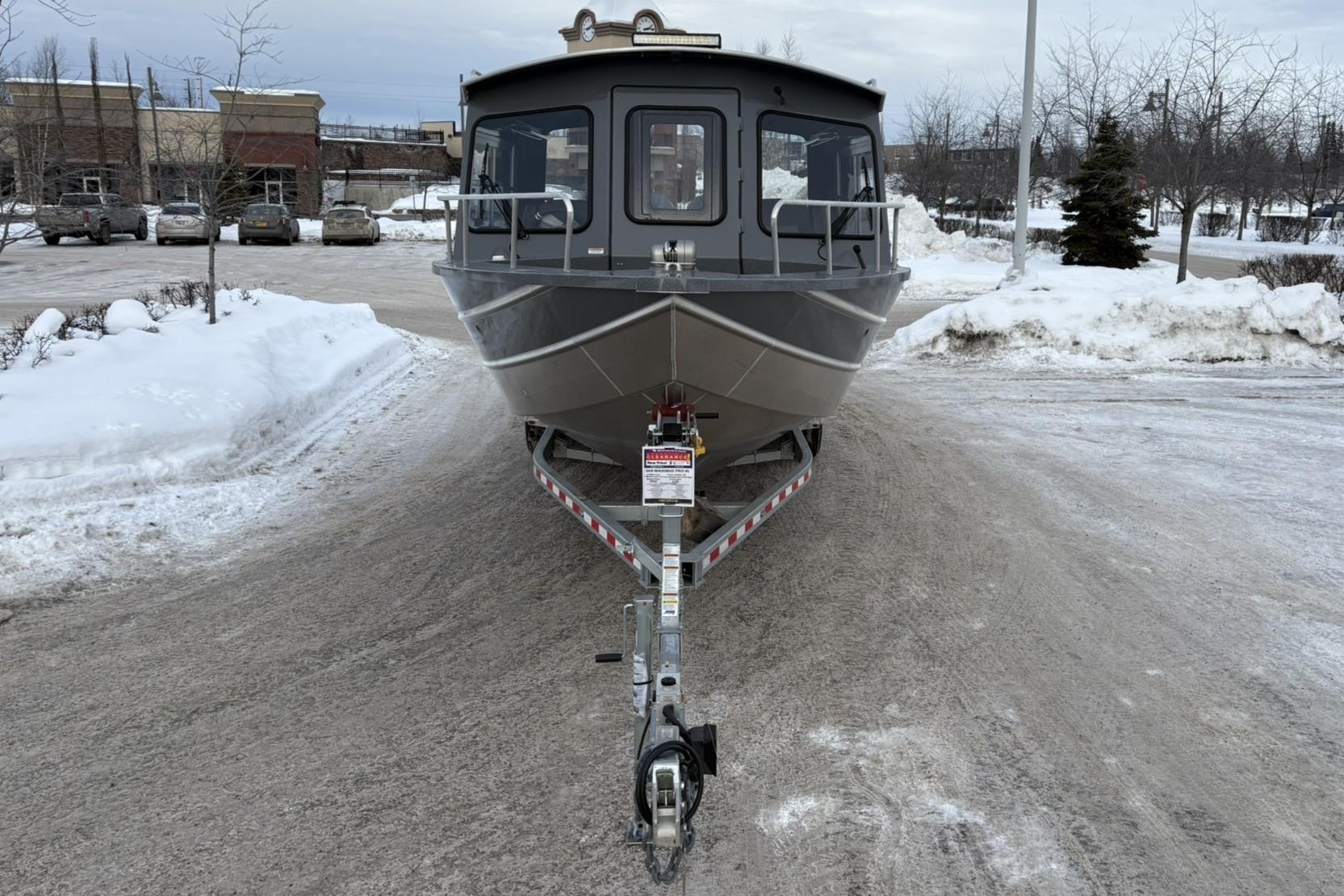 2024 Spartan 26 Maximus Pro XL boat on trailer in snowy parking lot.