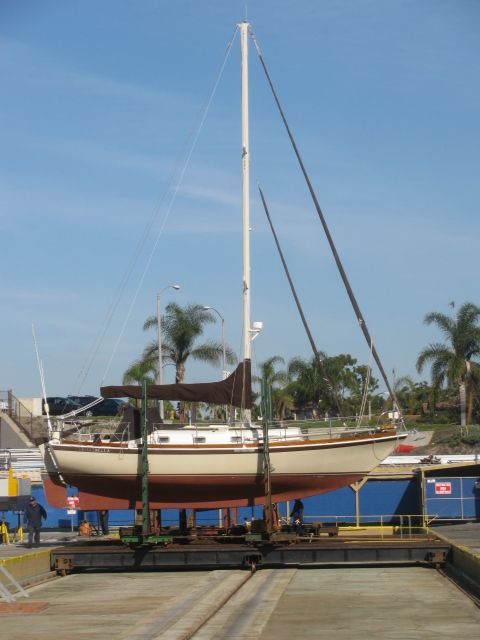 A sailboat is held on a stand on land.