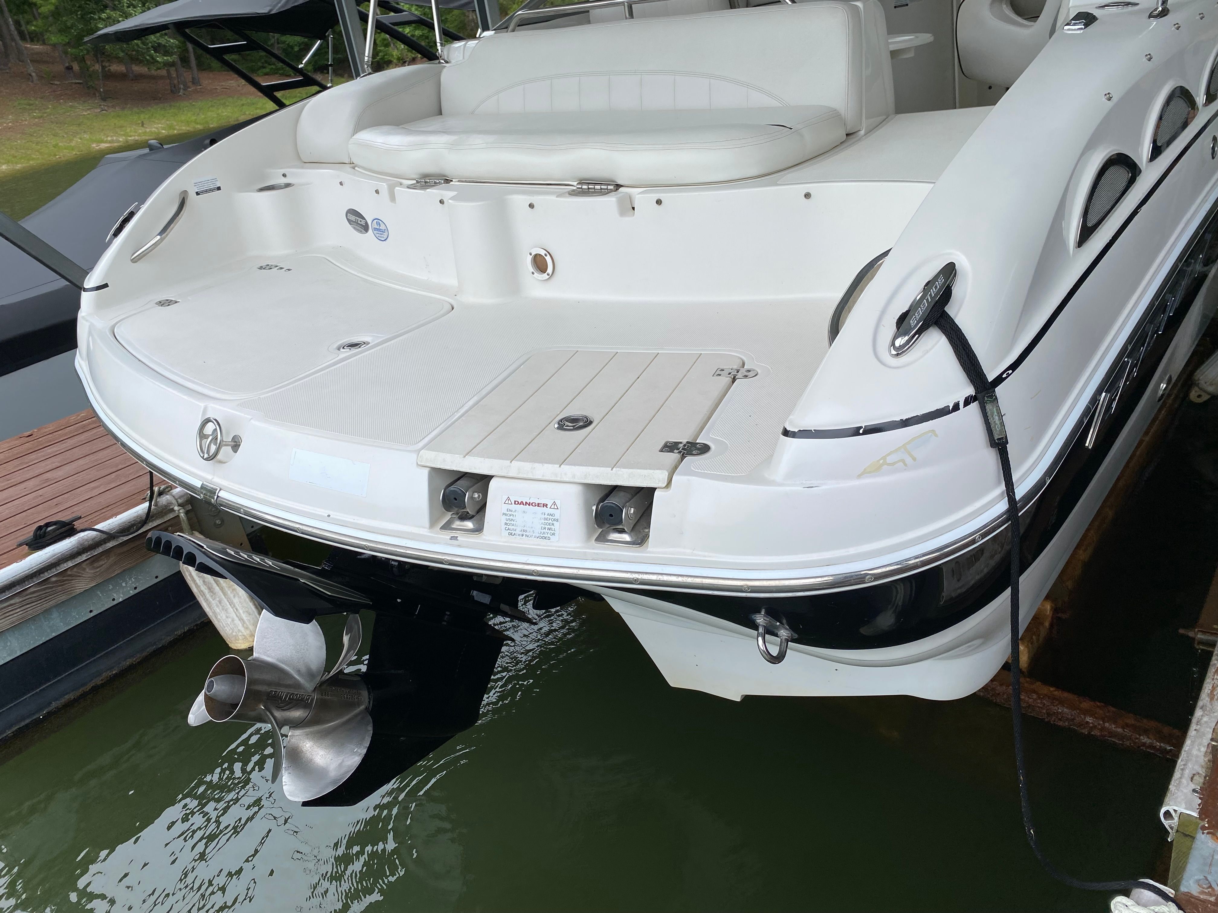 The image shows the stern of a 2007 Ebbtide 2460 Z-Trak boat docked.