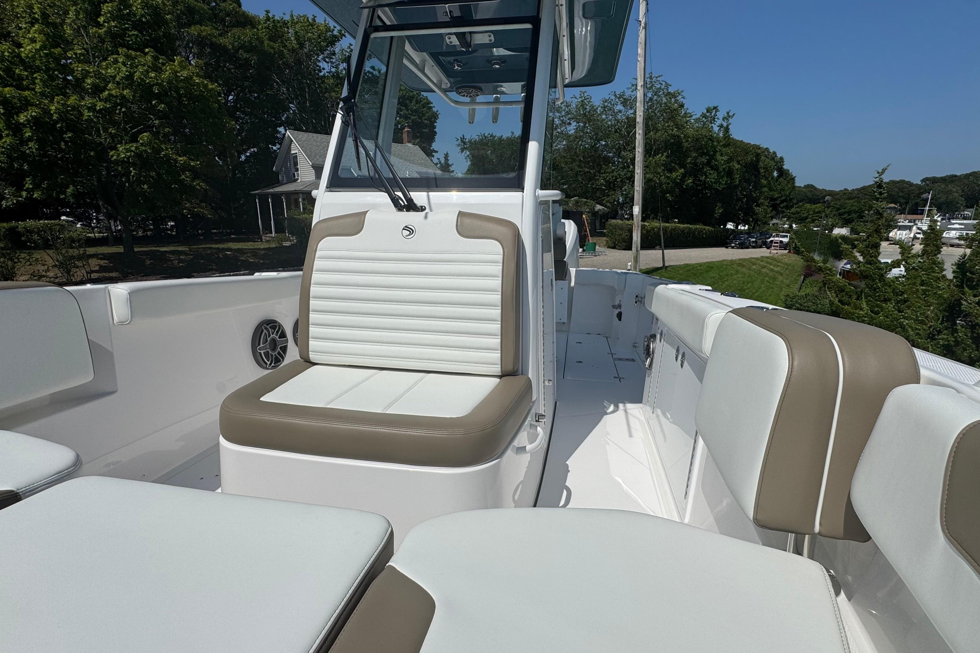 2026 Edgewater 250CC boat interior with white and tan seating, docked outdoors.