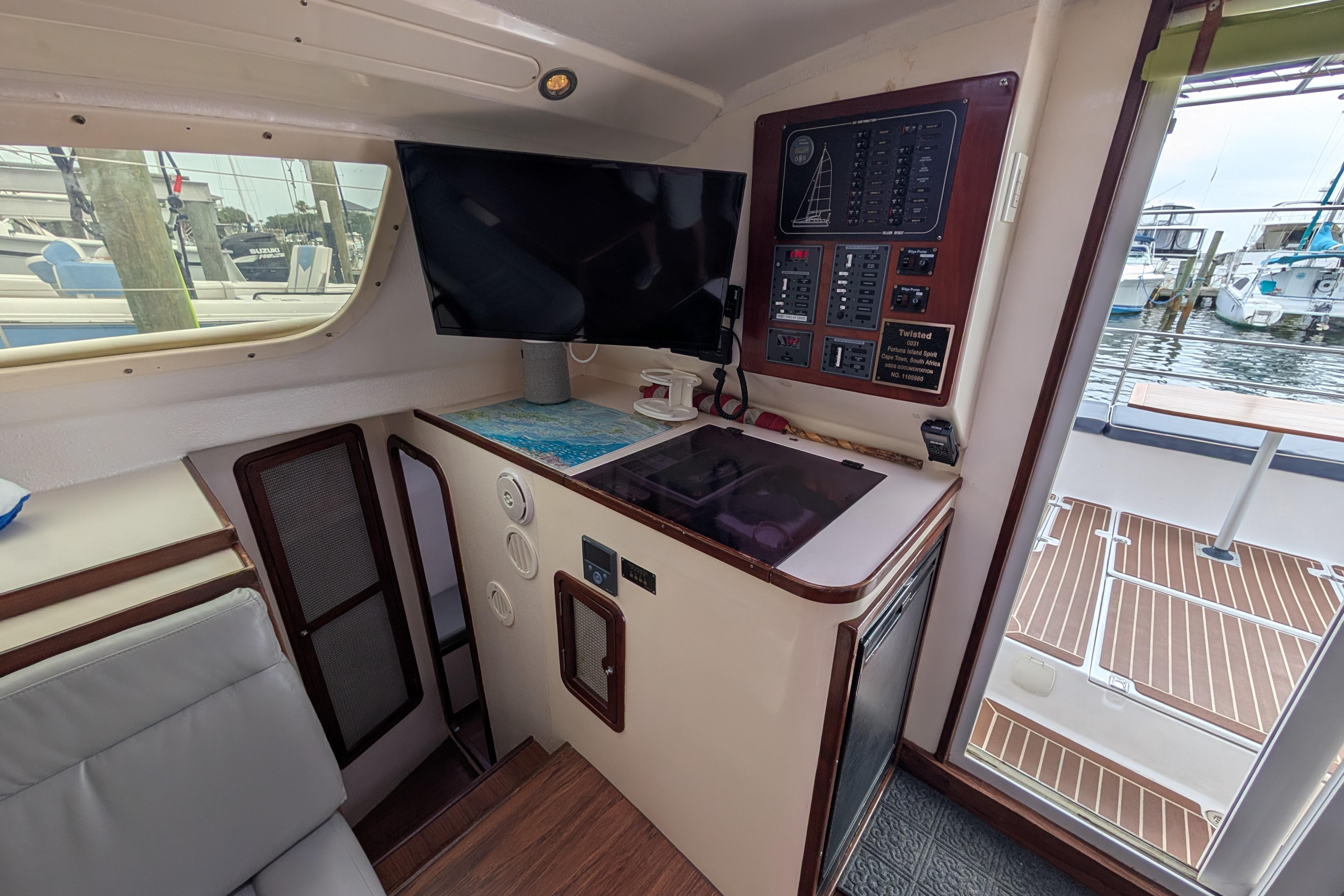 Interior of 1999 Island Spirit 37 yacht with control panel and TV, dockside view.