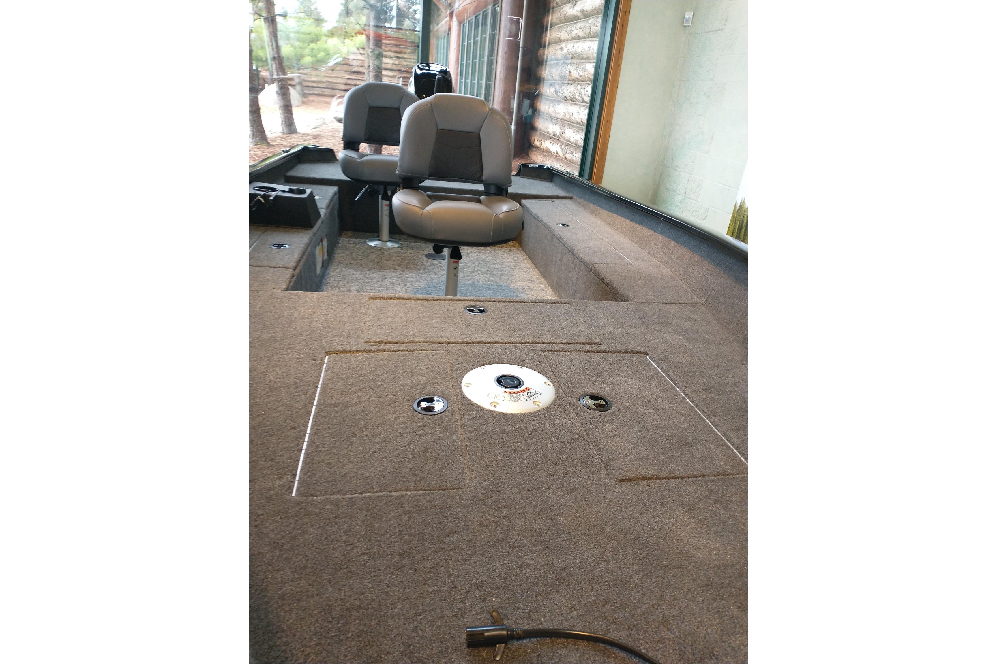 Interior of 2025 Tracker Super Guide V-16 T boat with seating and carpeted deck.