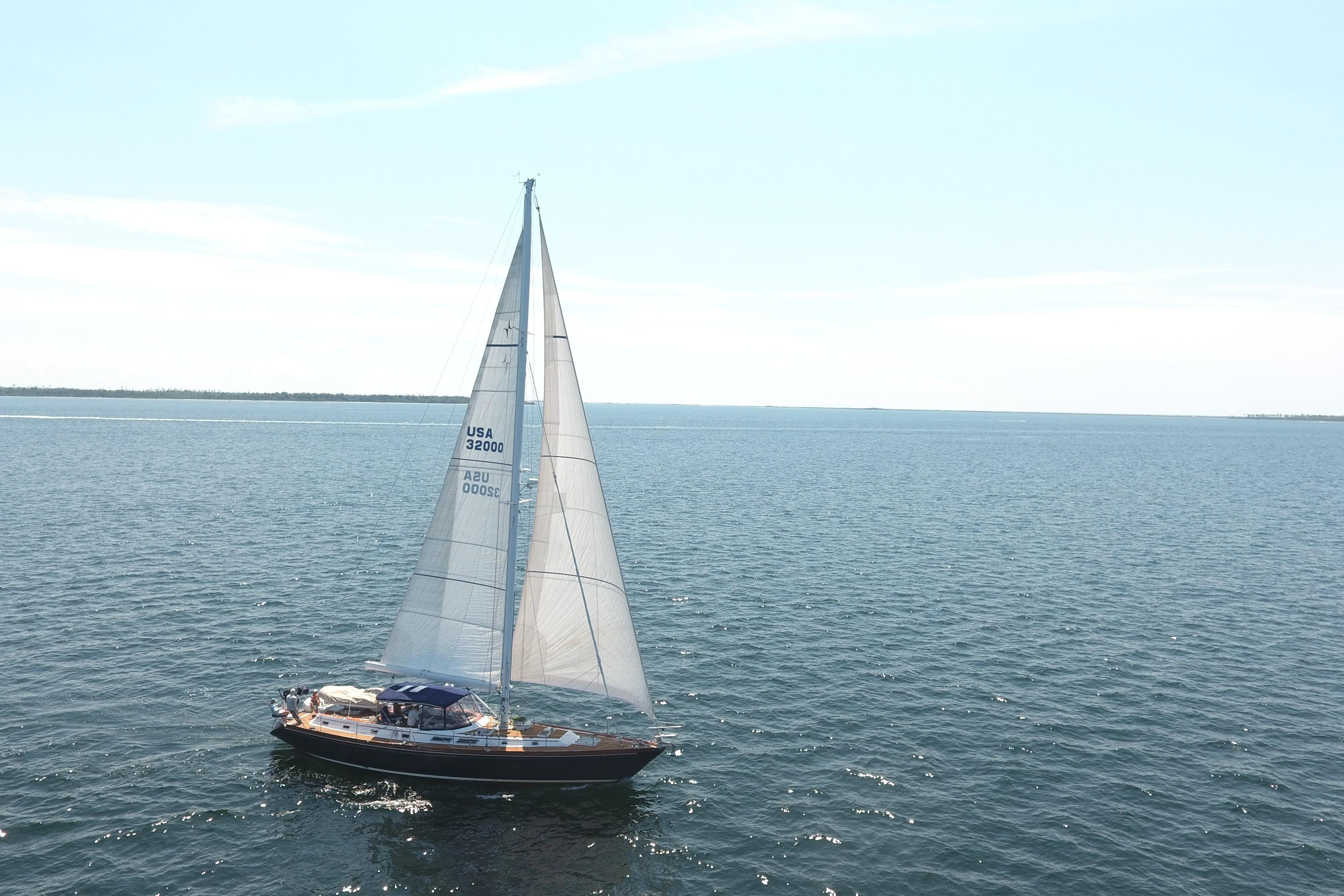 Sailing yacht Gulfstar 60 CC, 1981 model, cruising on open sea under clear skies.