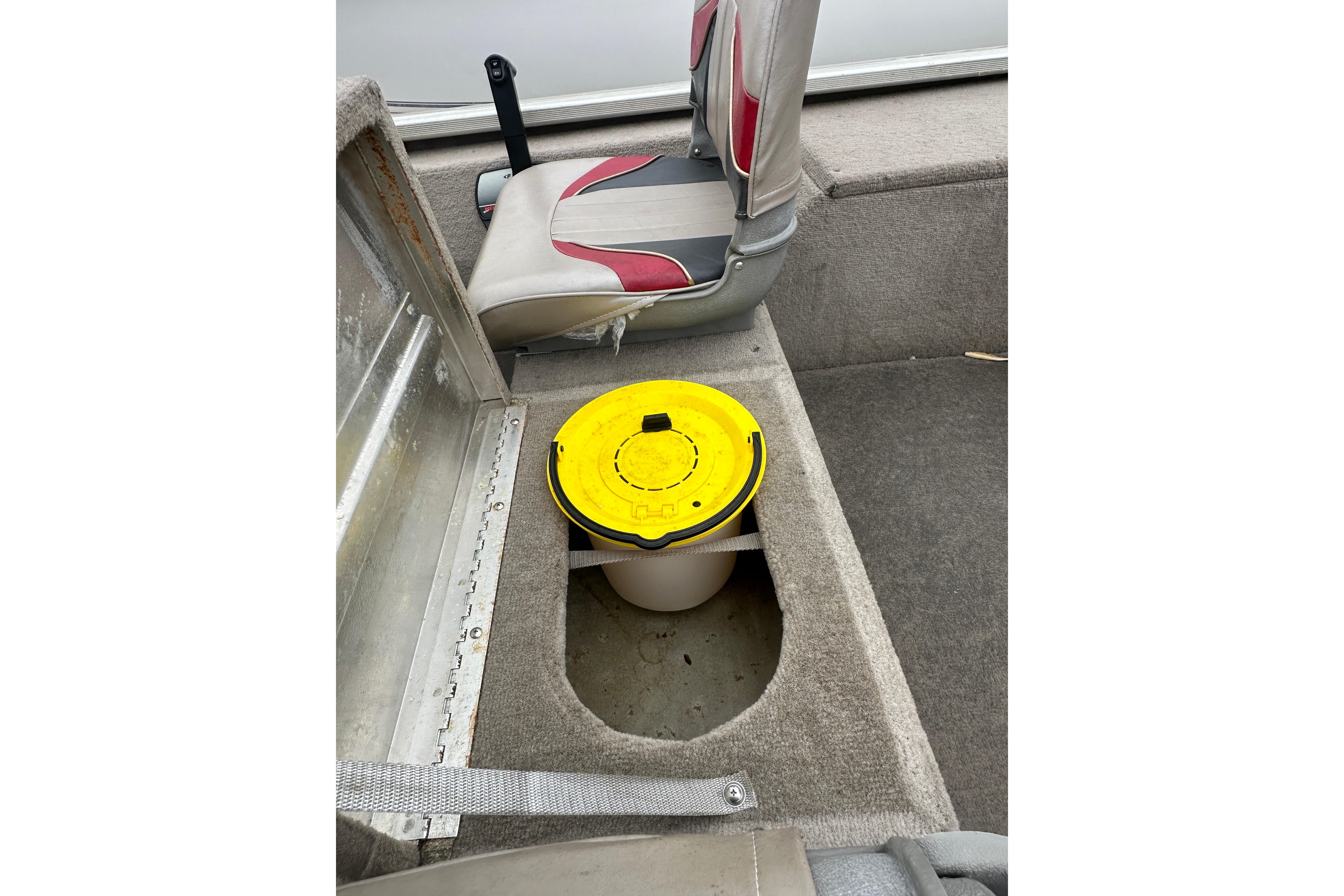Interior of a 2002 Fisher 1710 boat with a yellow-lidded container.
