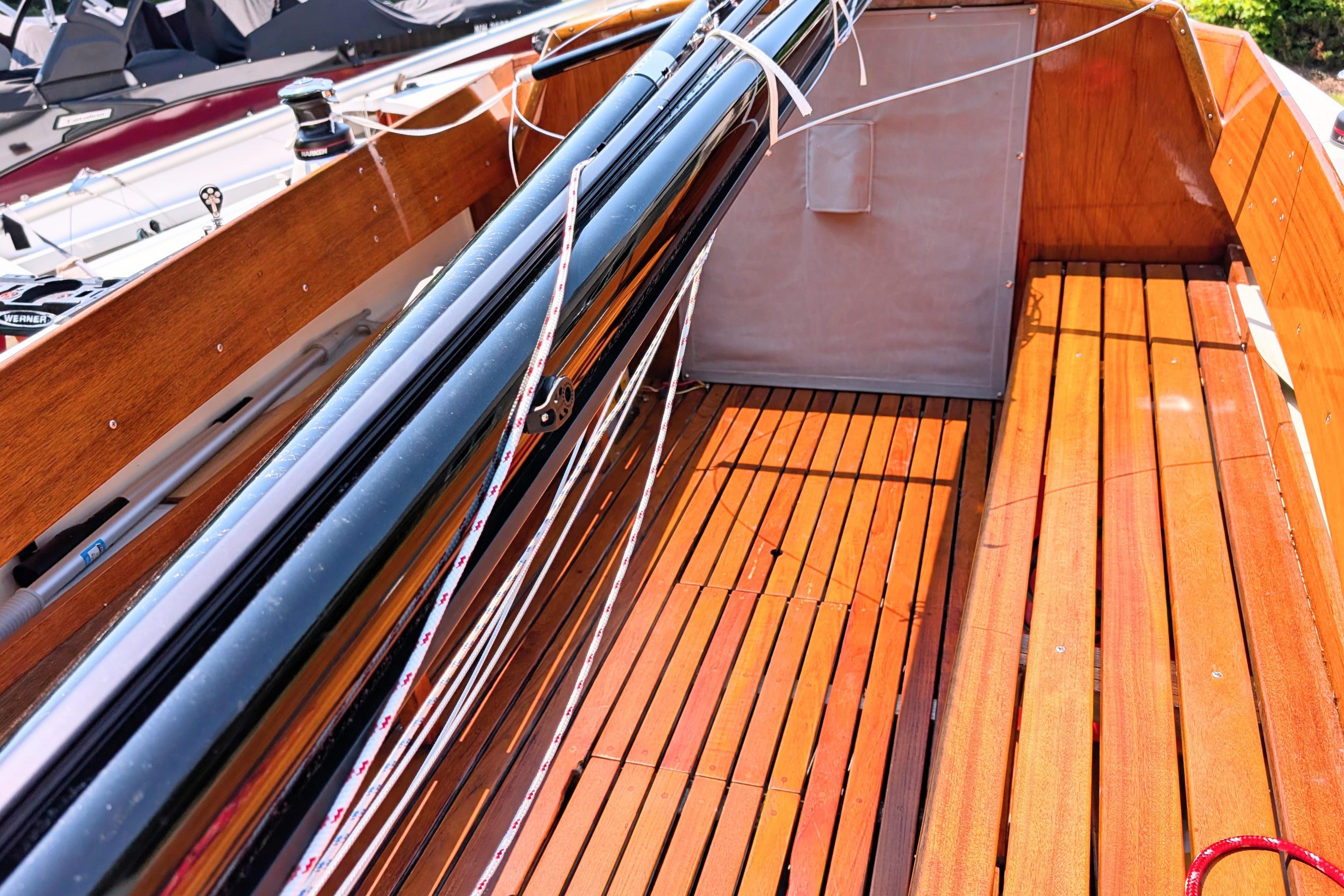 Interior of a 1965 Pearson Ensign sailboat with polished wooden deck and rigging.
