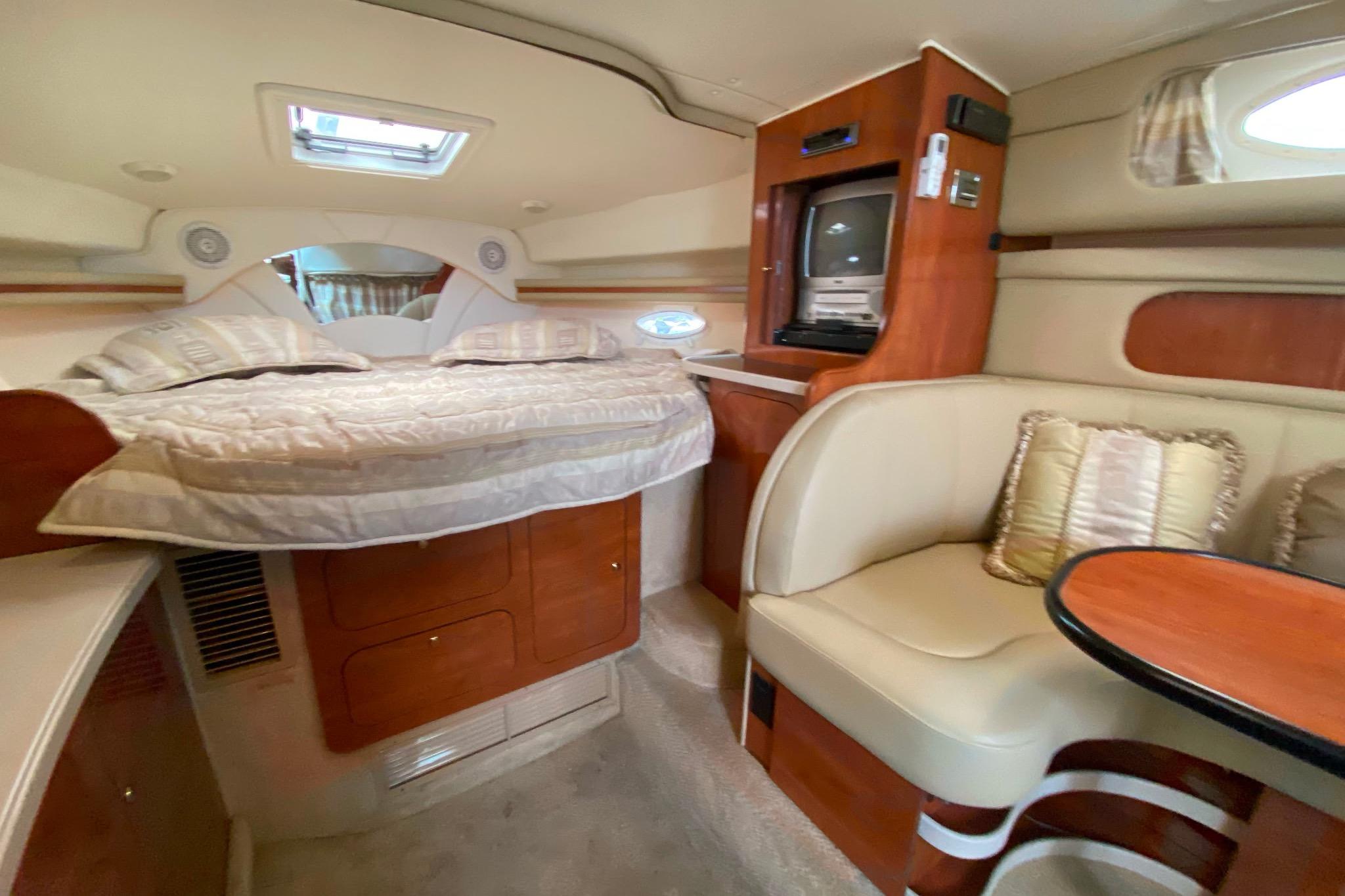 2003 Rinker Fiesta Vee 342 cabin interior with bed, seating, and entertainment system.