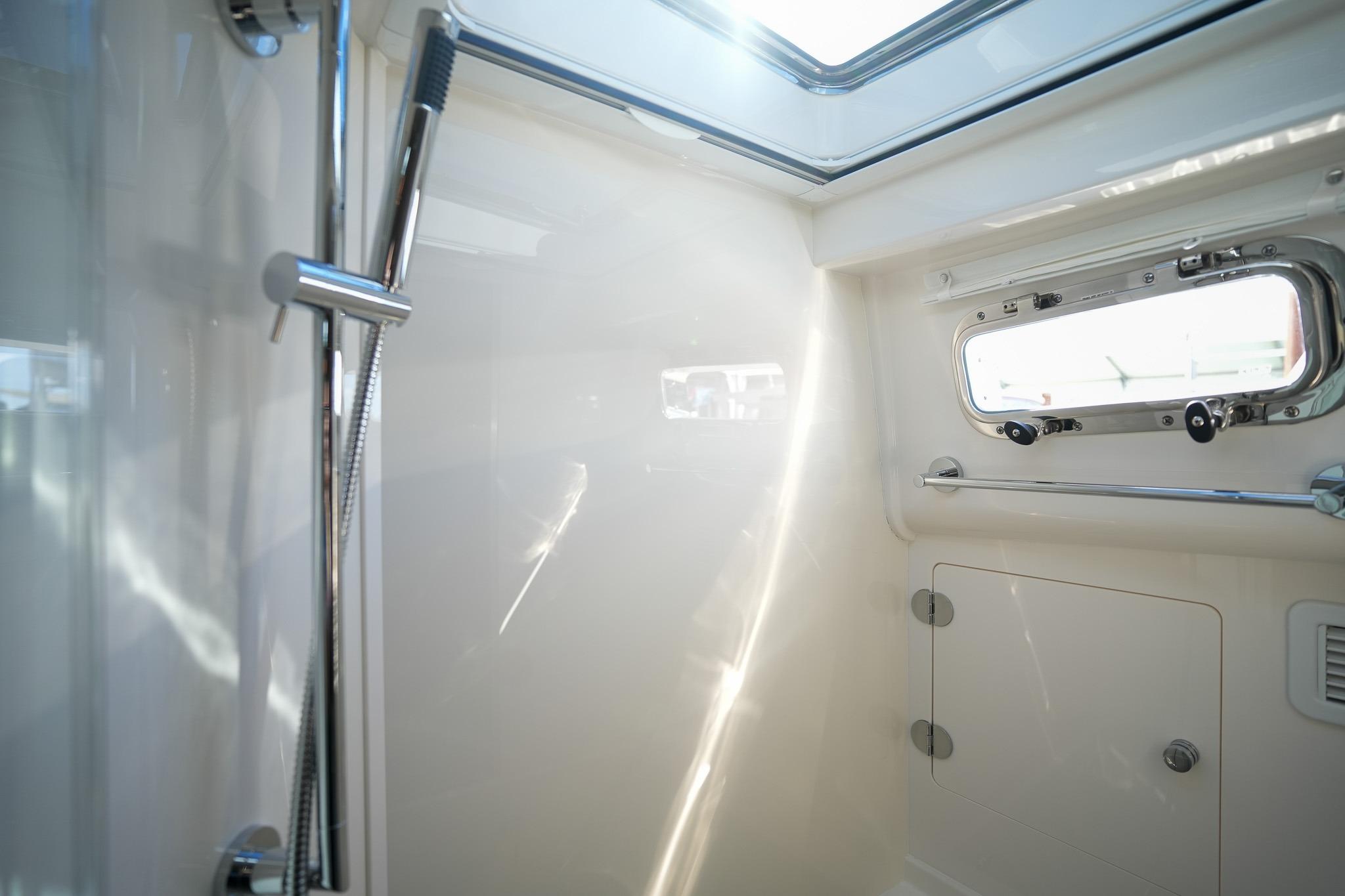 Interior of 2026 Sabre 51 Salon Express yacht shower with window and chrome fixtures.