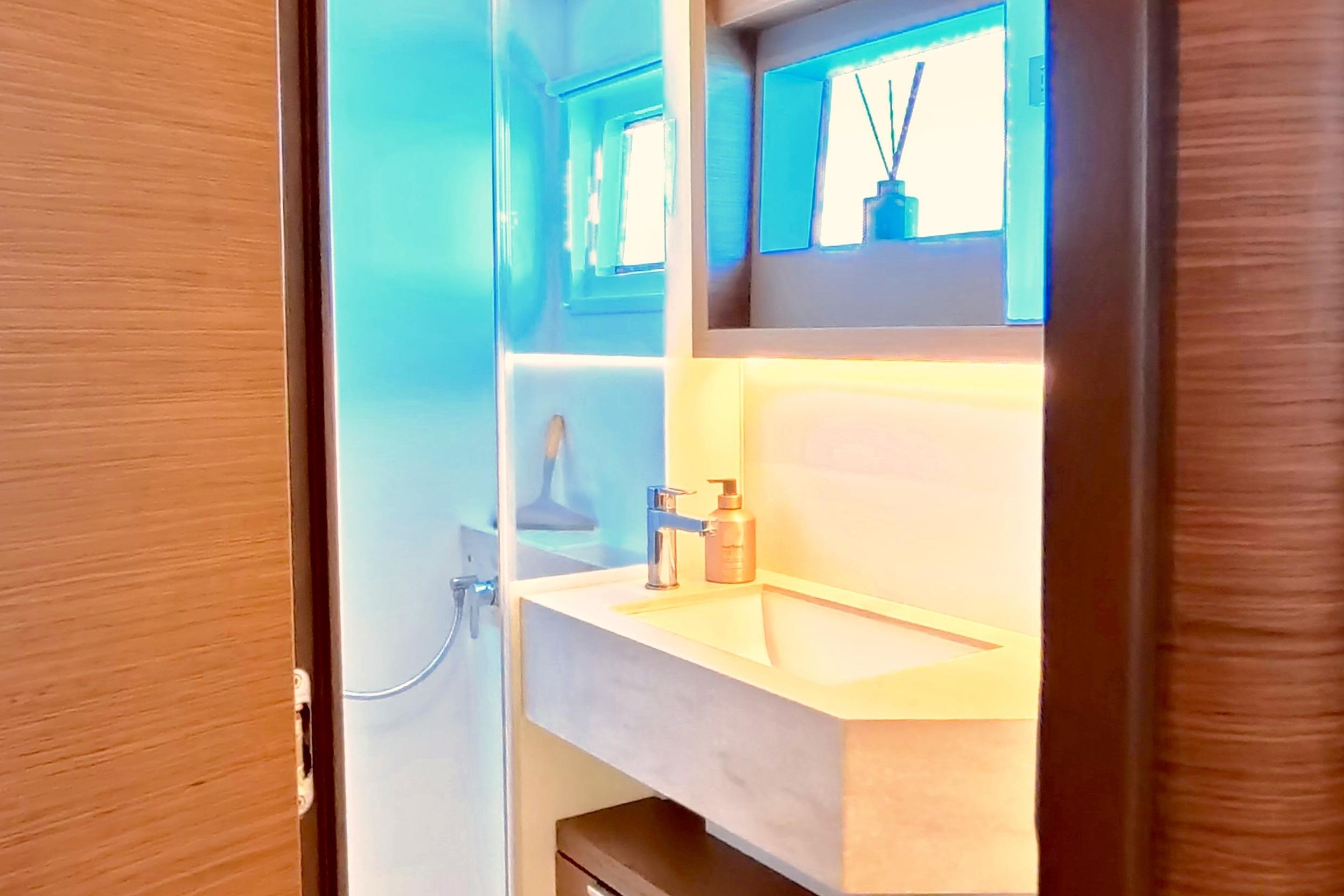 Modern bathroom interior on 2023 Lagoon 50 yacht, featuring sleek sink and ambient lighting.