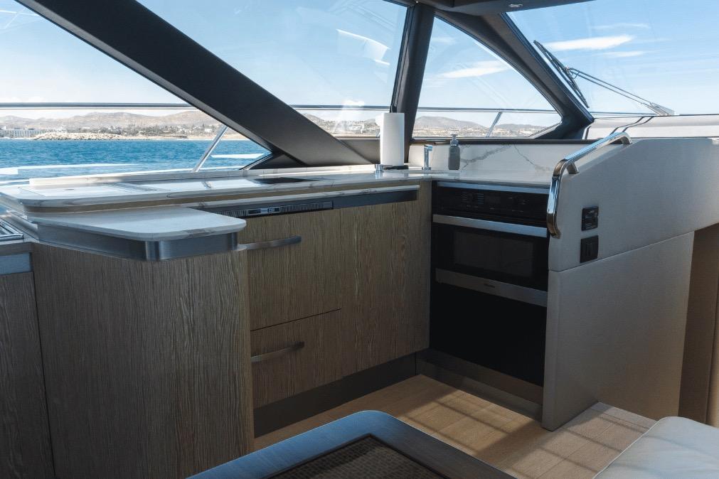 Modern kitchen interior on a 2020 Azimut 60 yacht with ocean view.