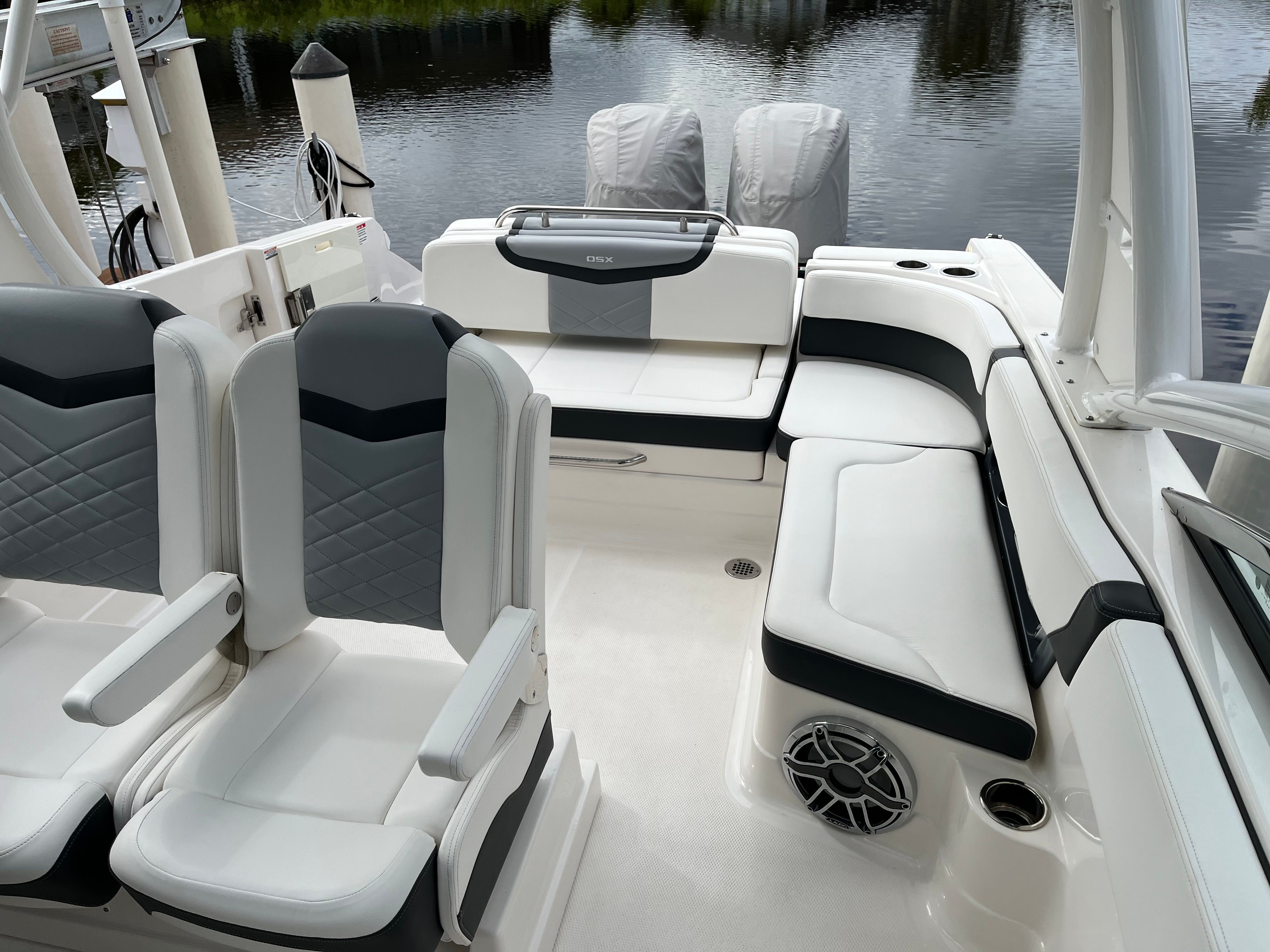 The image shows the cockpit of a 2023 Chaparral 28 OSX with sleek white seating.