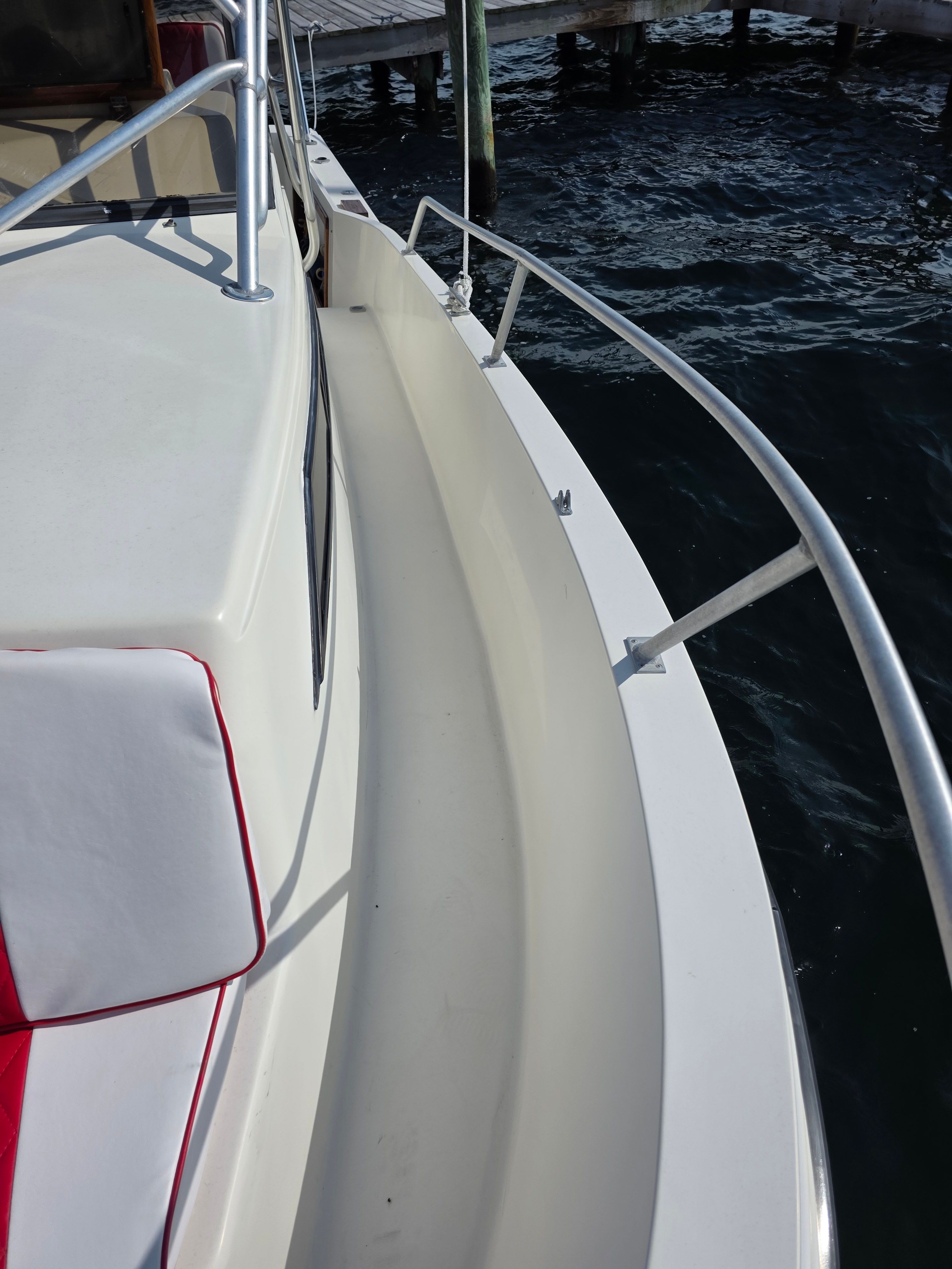1987 Mako 248 WAC boat deck with railing by the water.