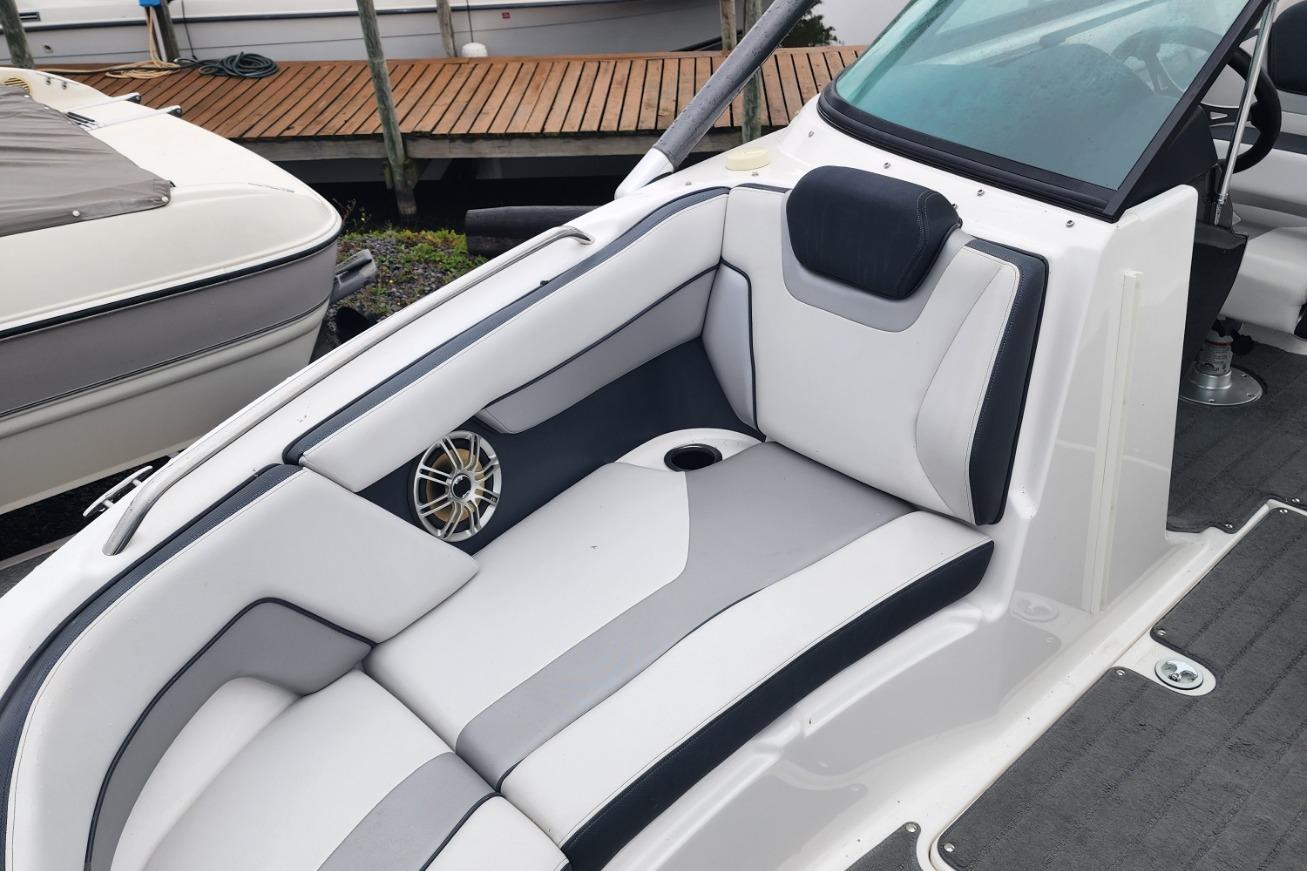 2015 Yamaha Boats 212X interior with sleek white and gray seating, cup holder, and speaker.