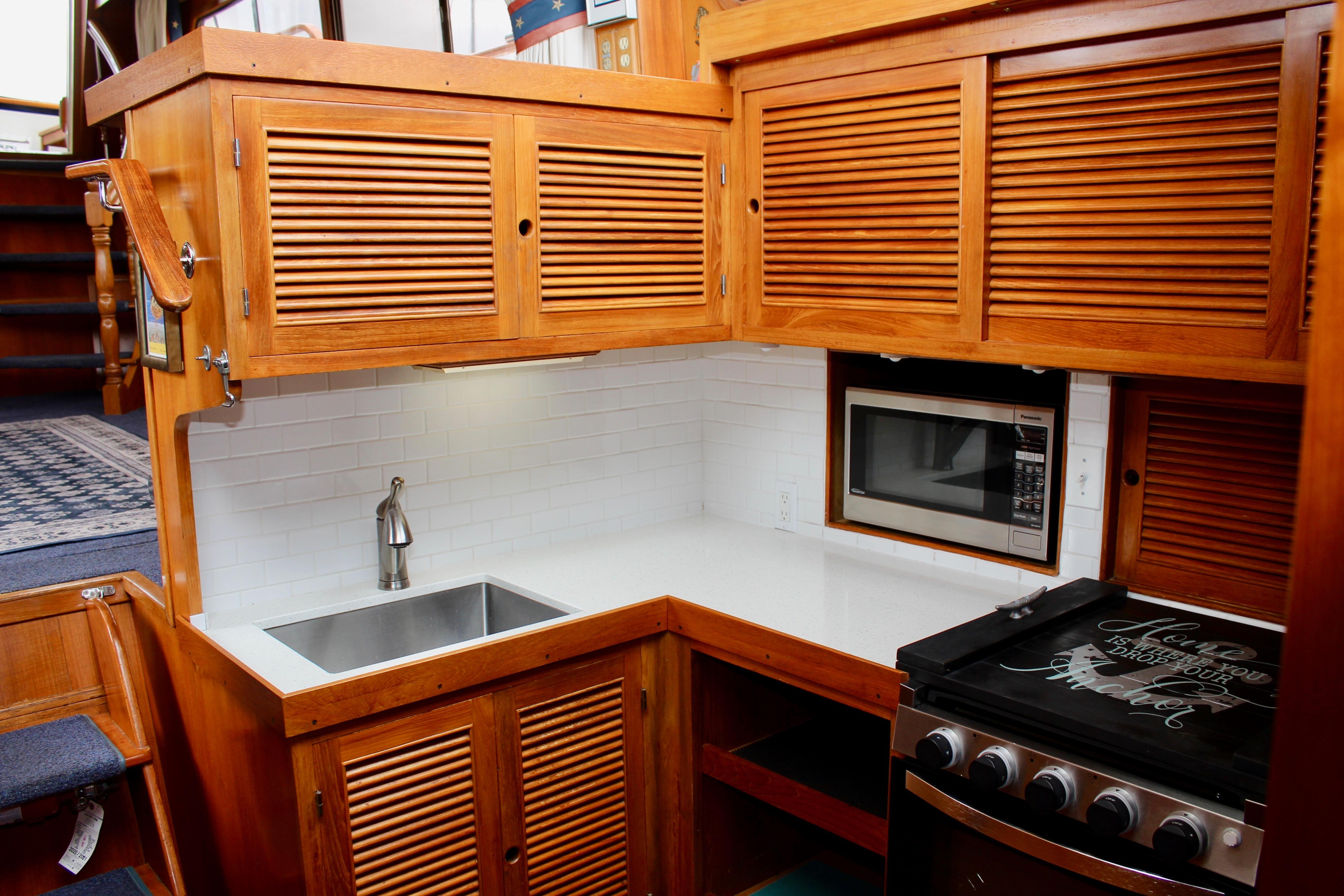 1986 Kha Shing Spindrift 46 yacht kitchen with wooden cabinets, sink, and appliances.