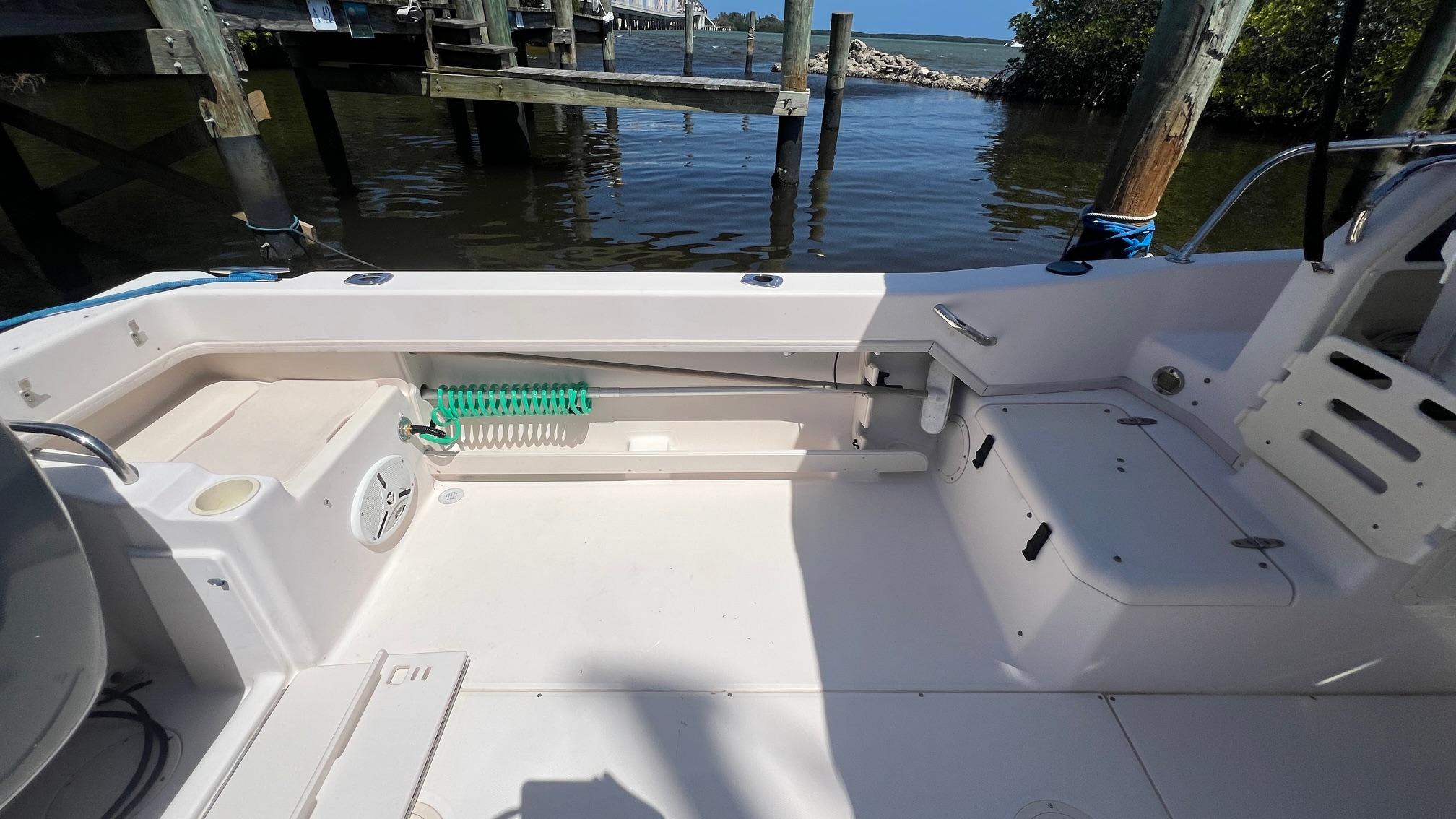 2005 Grady-White Seafarer 226 boat interior, featuring seating and storage, docked by the water.