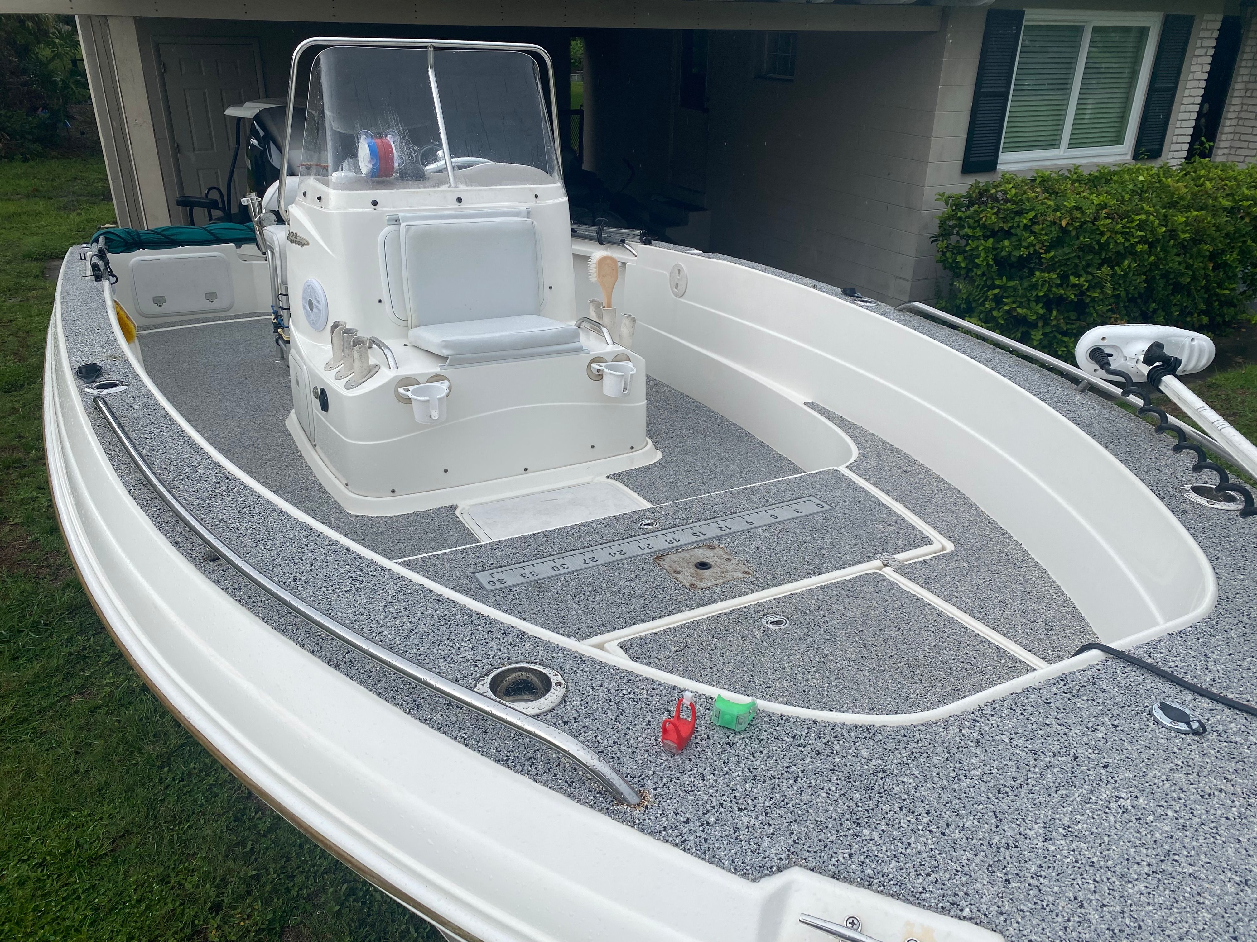 A 2003 Aquasport 201 Osprey with a gray deck and white console, parked outdoors.