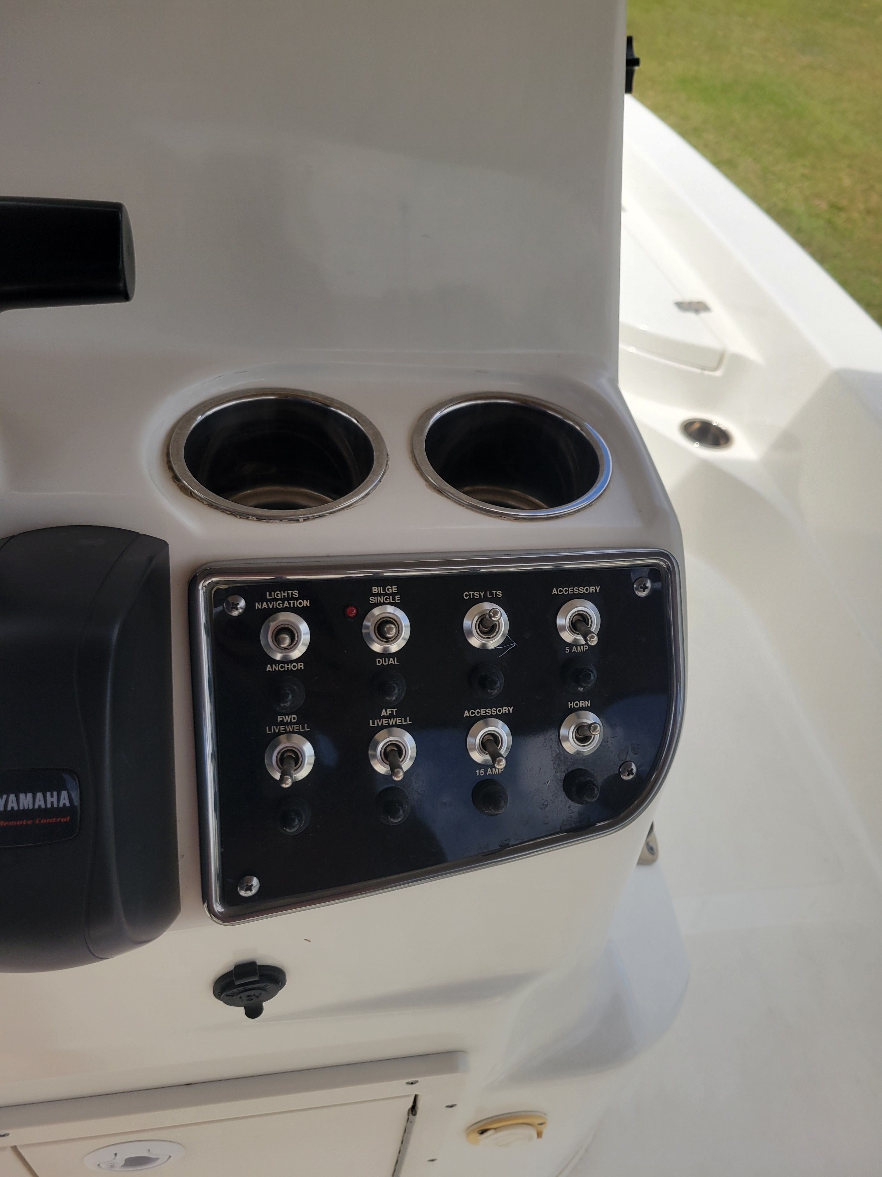 Boat dashboard with switches and cup holders.