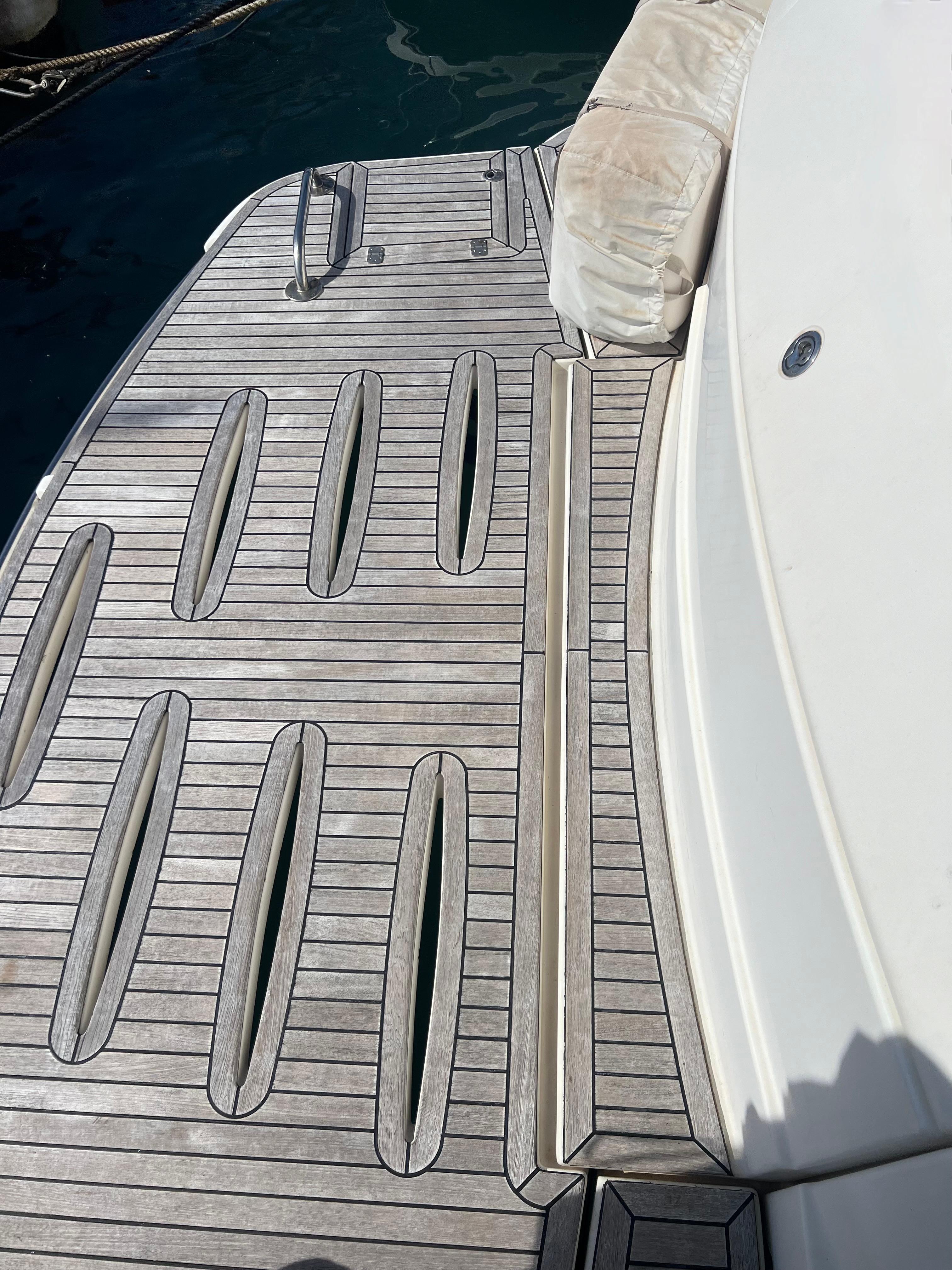 2008 Riviera 4700 Sport Yacht deck with teak flooring and cushioned seating.