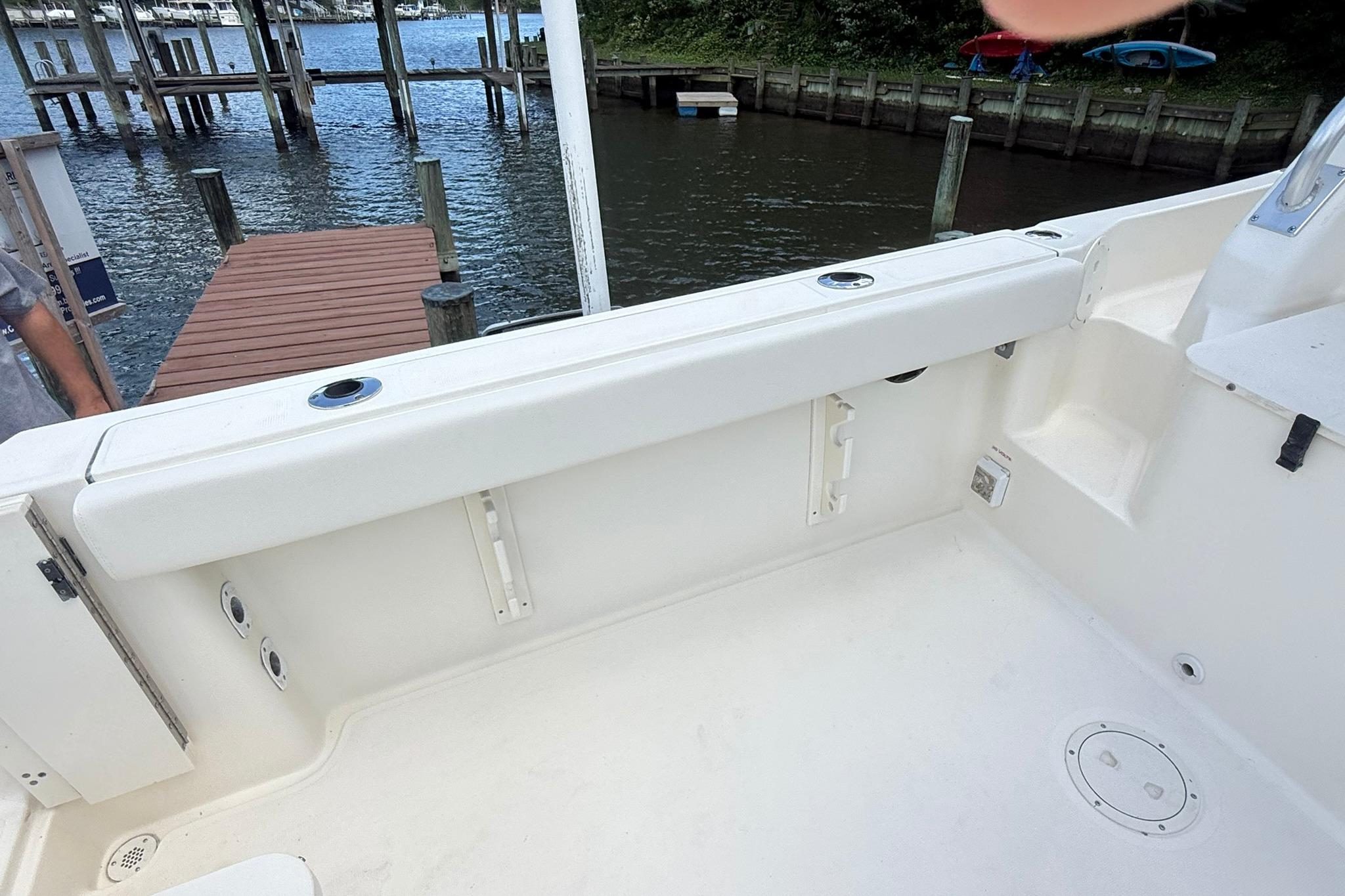 2003 Pursuit 2870 Walkaround boat interior near dock, showcasing spacious seating area.