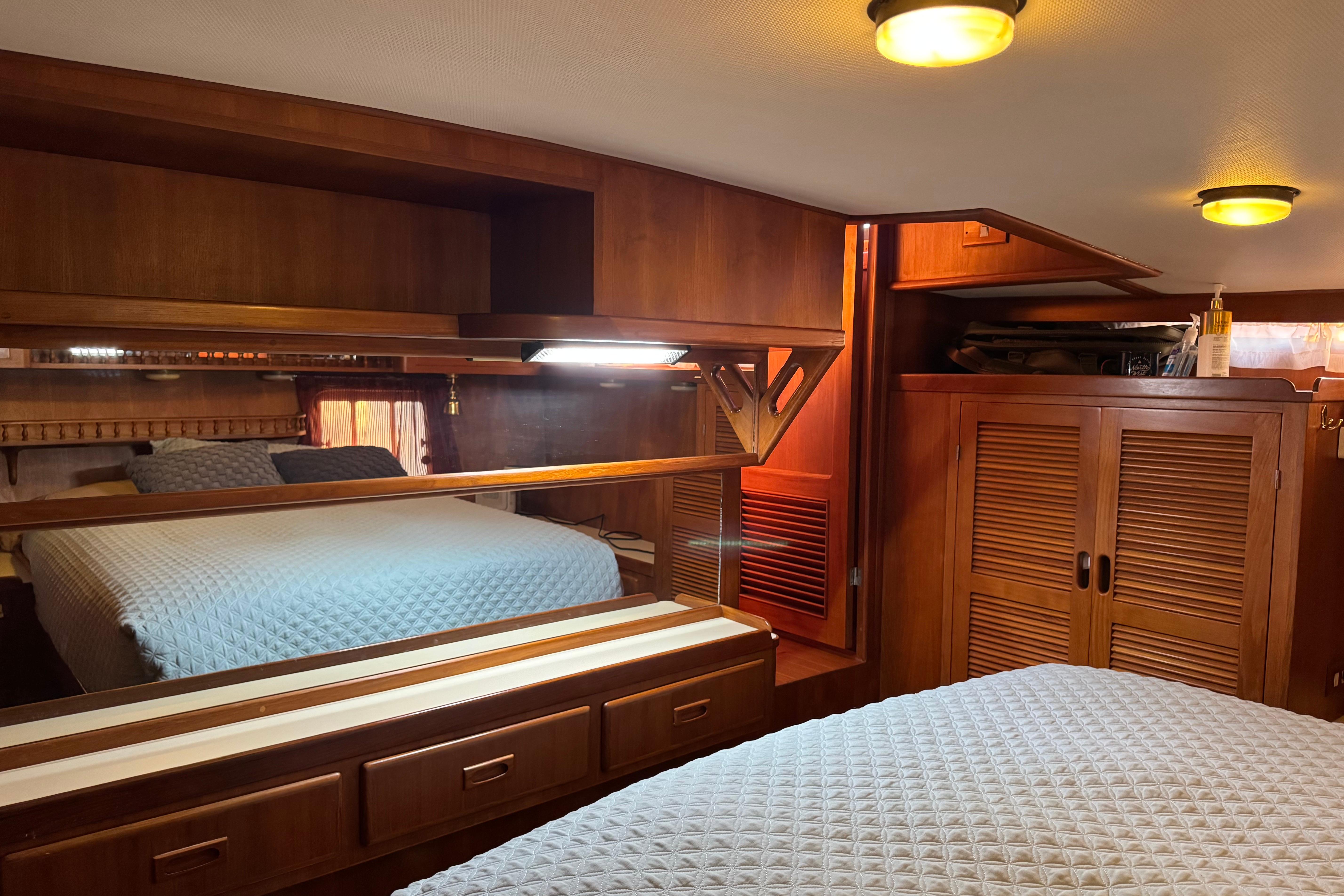 Luxurious 1987 President 37 yacht bedroom with wooden cabinetry and cozy bedding.