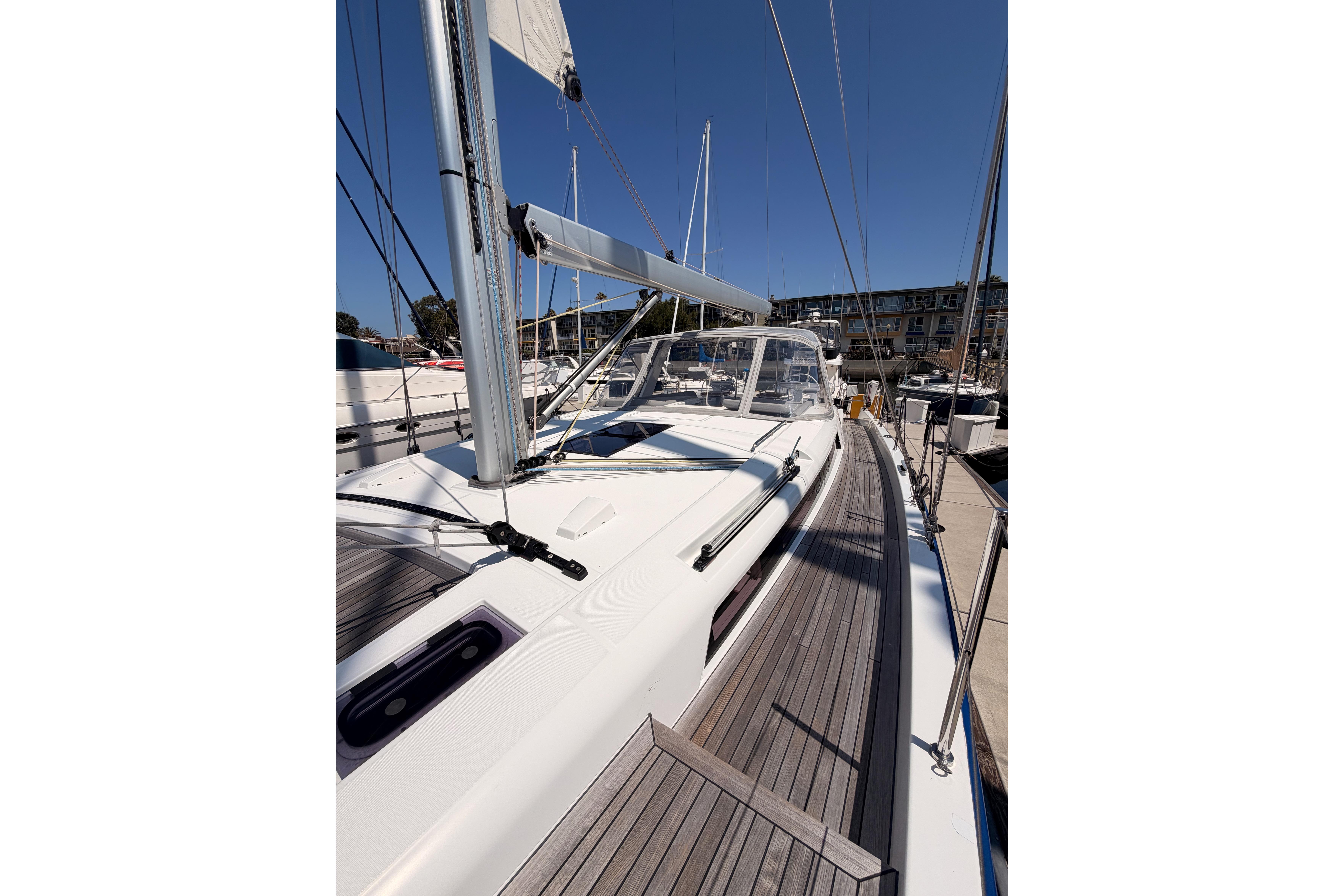 2022 Beneteau Oceanis Yacht 54, sleek deck design, docked under clear blue sky.