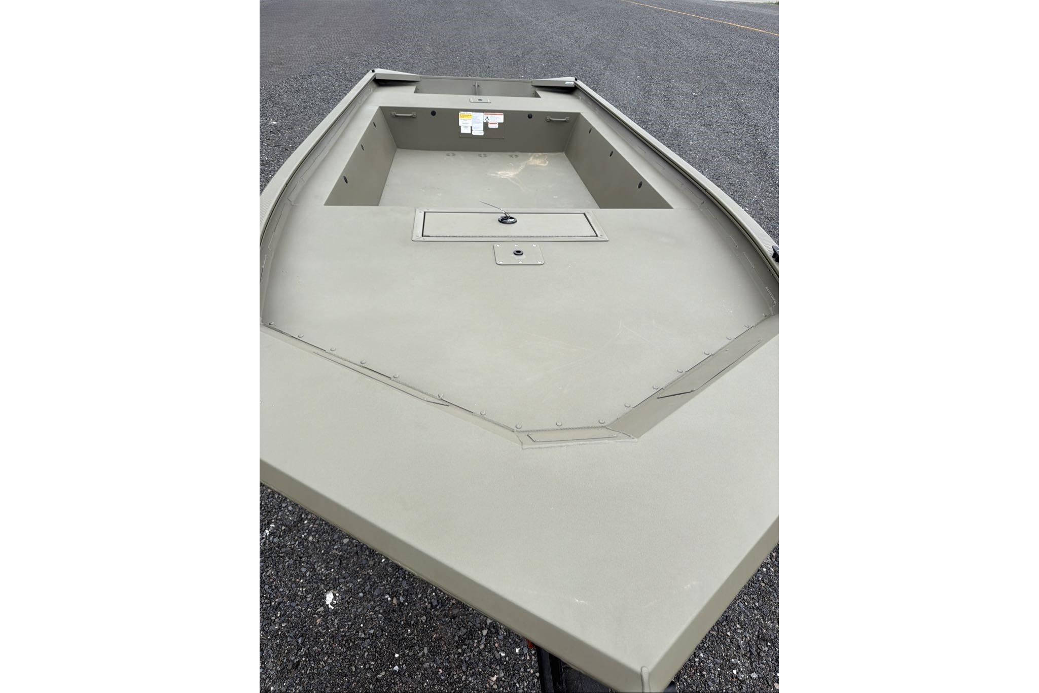 2026 Tracker Grizzly 1754 Utility boat, empty deck view on asphalt surface.