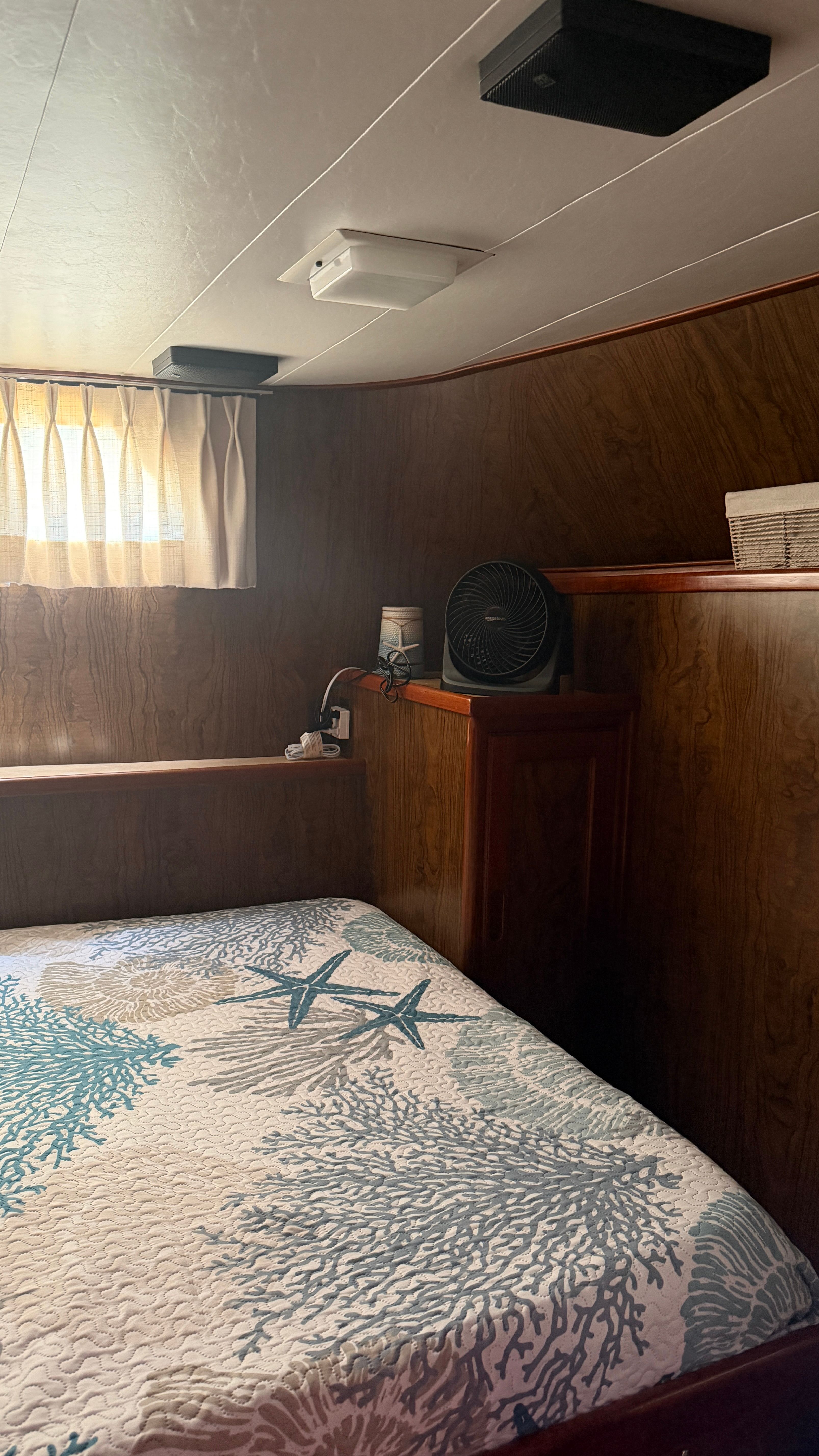 Interior of a 1966 Drake Yachtfisher with bed and fan.