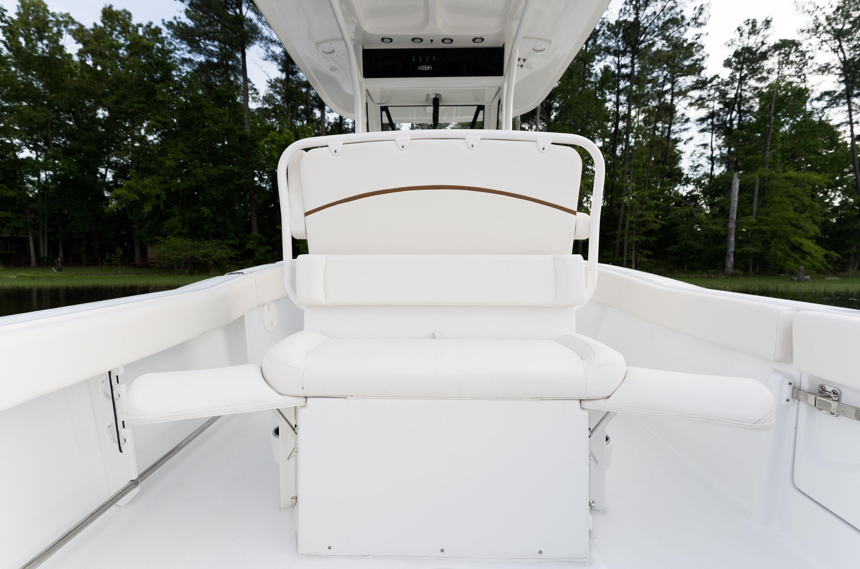 2024 Sea Hunt Ultra 239 SE boat interior with white seating and lush green background.