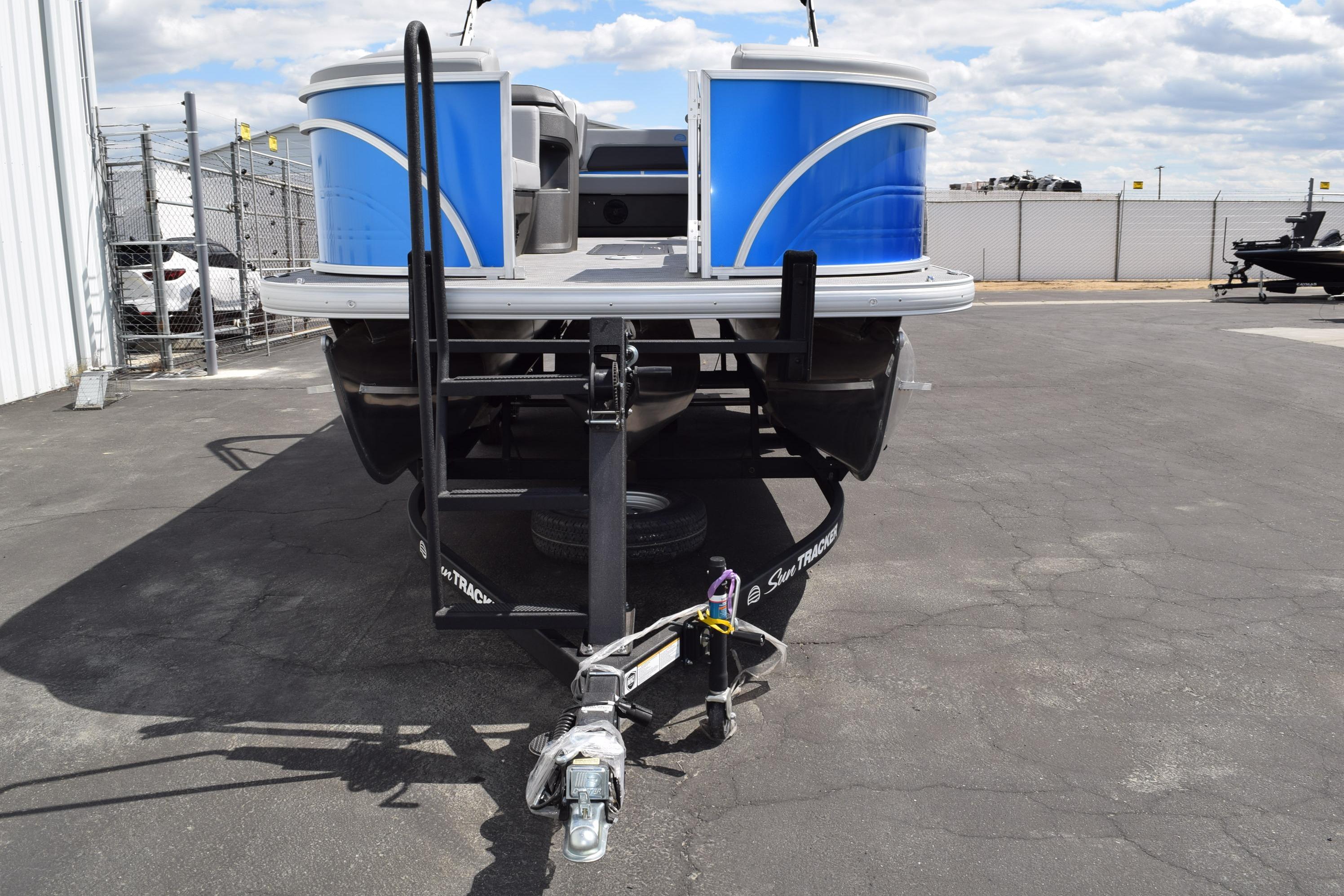 2026 Sun Tracker Party Barge 22 RF XP3 pontoon boat on trailer, parked outdoors.