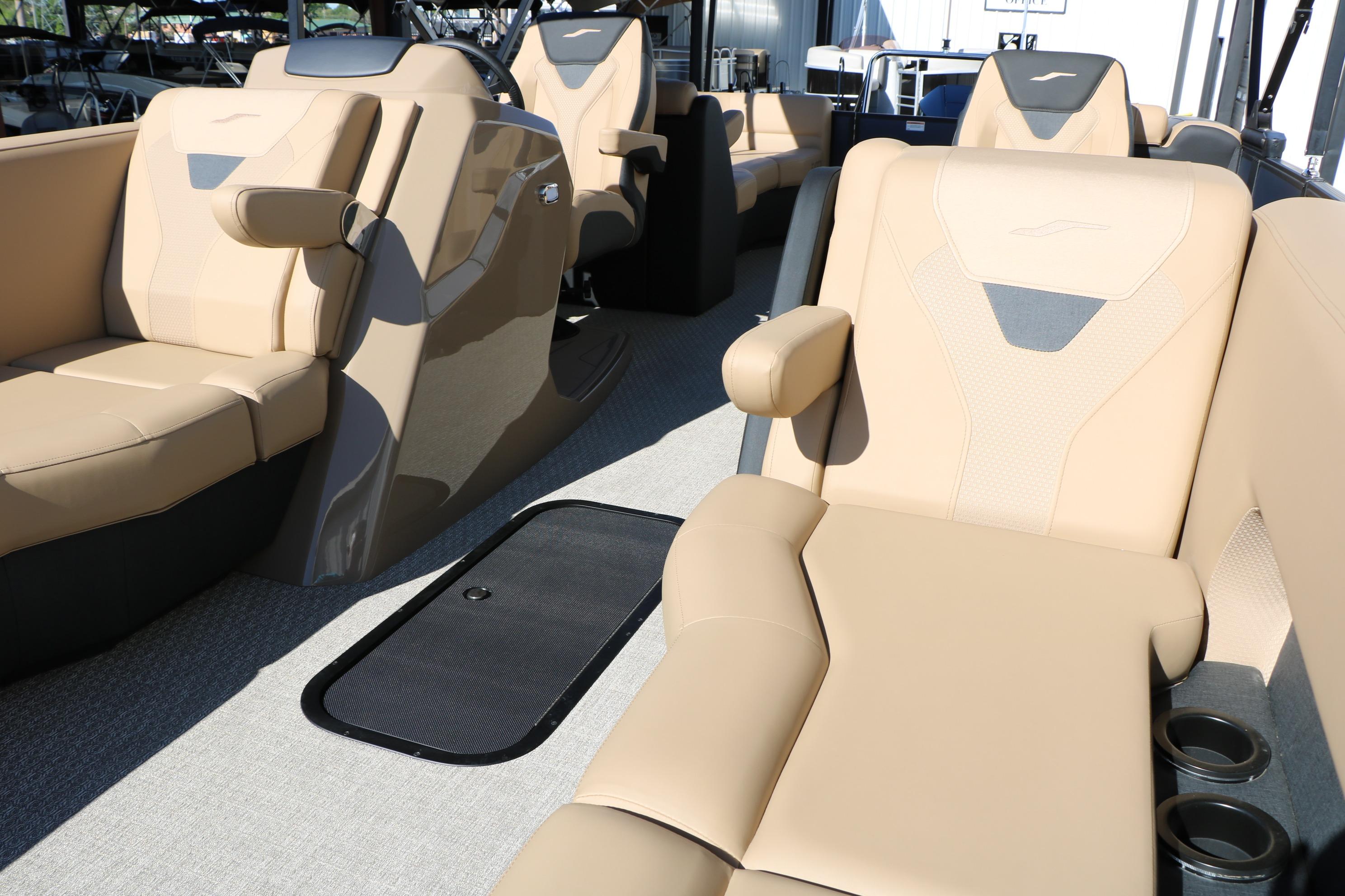 Luxurious seating on 2026 Evotti 525 QL Tri-Toon boat, featuring beige upholstery and cup holders.