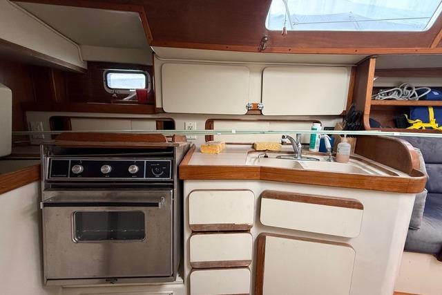 1987 Irwin 38 Mk II yacht kitchen with stove, sink, and storage cabinets.
