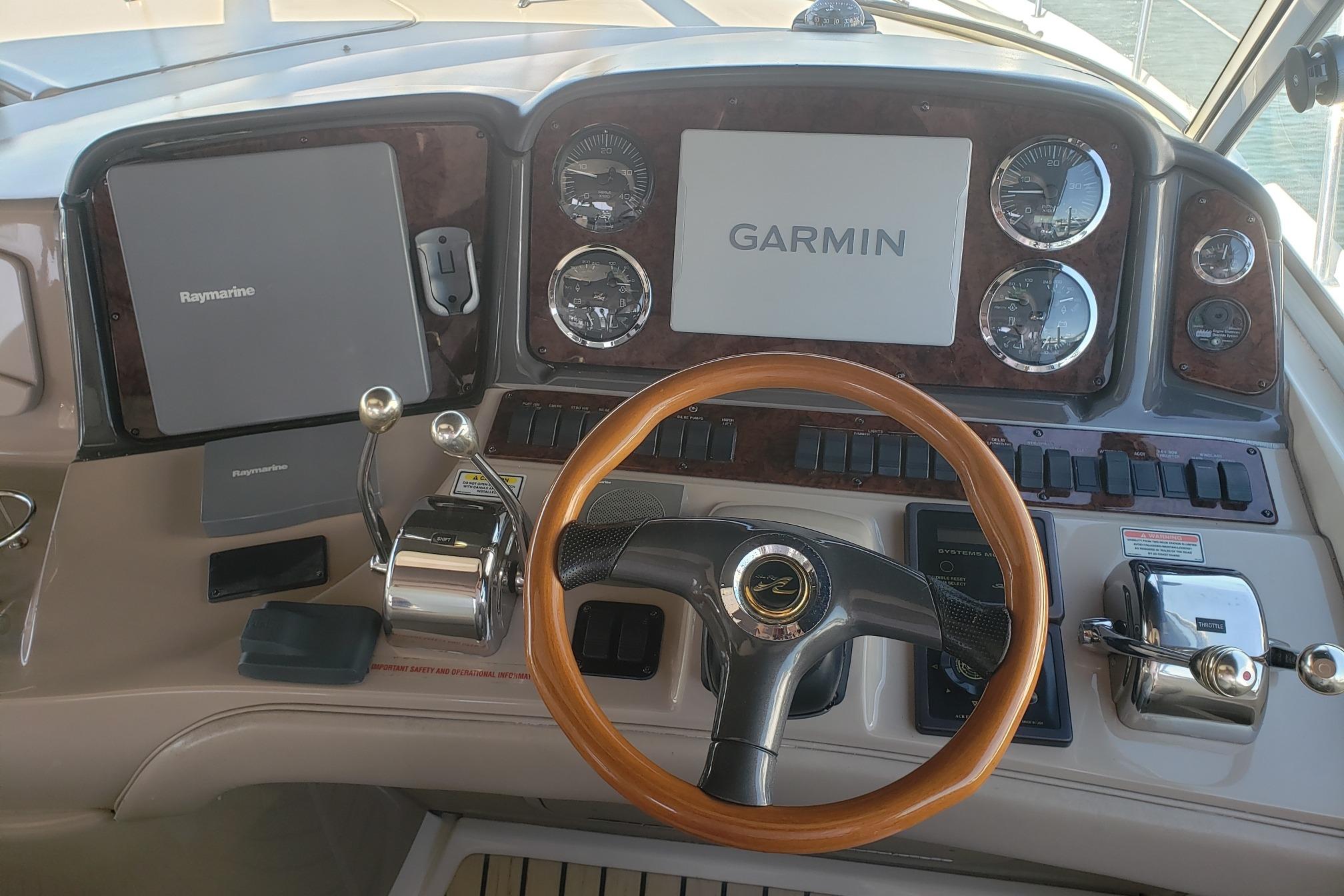 Helm of 2003 Sea Ray 420 Sundancer with Garmin and Raymarine navigation systems.