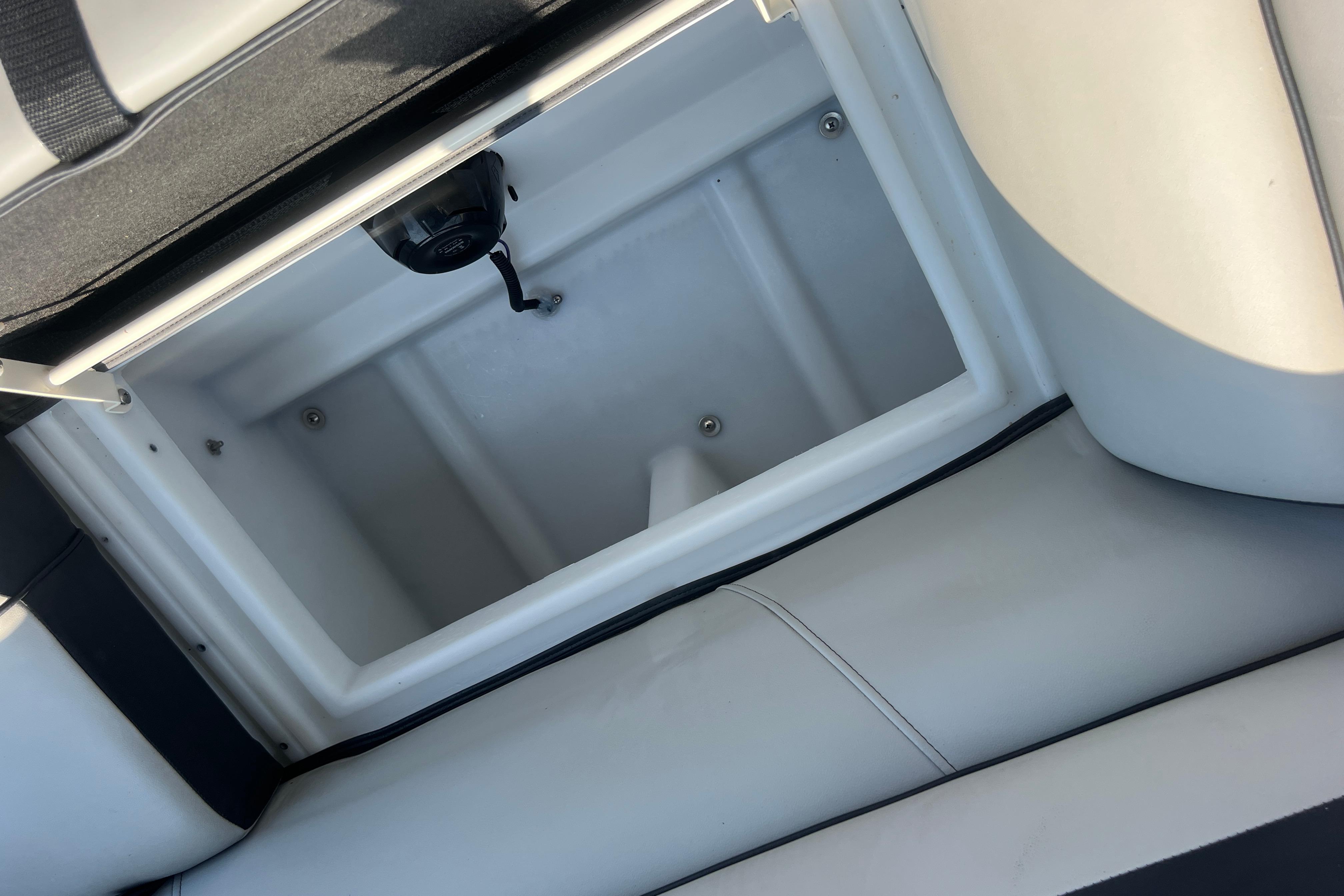 Open storage compartment in 2022 Viaggio Lago V-U 22 boat, featuring sleek white interior design.