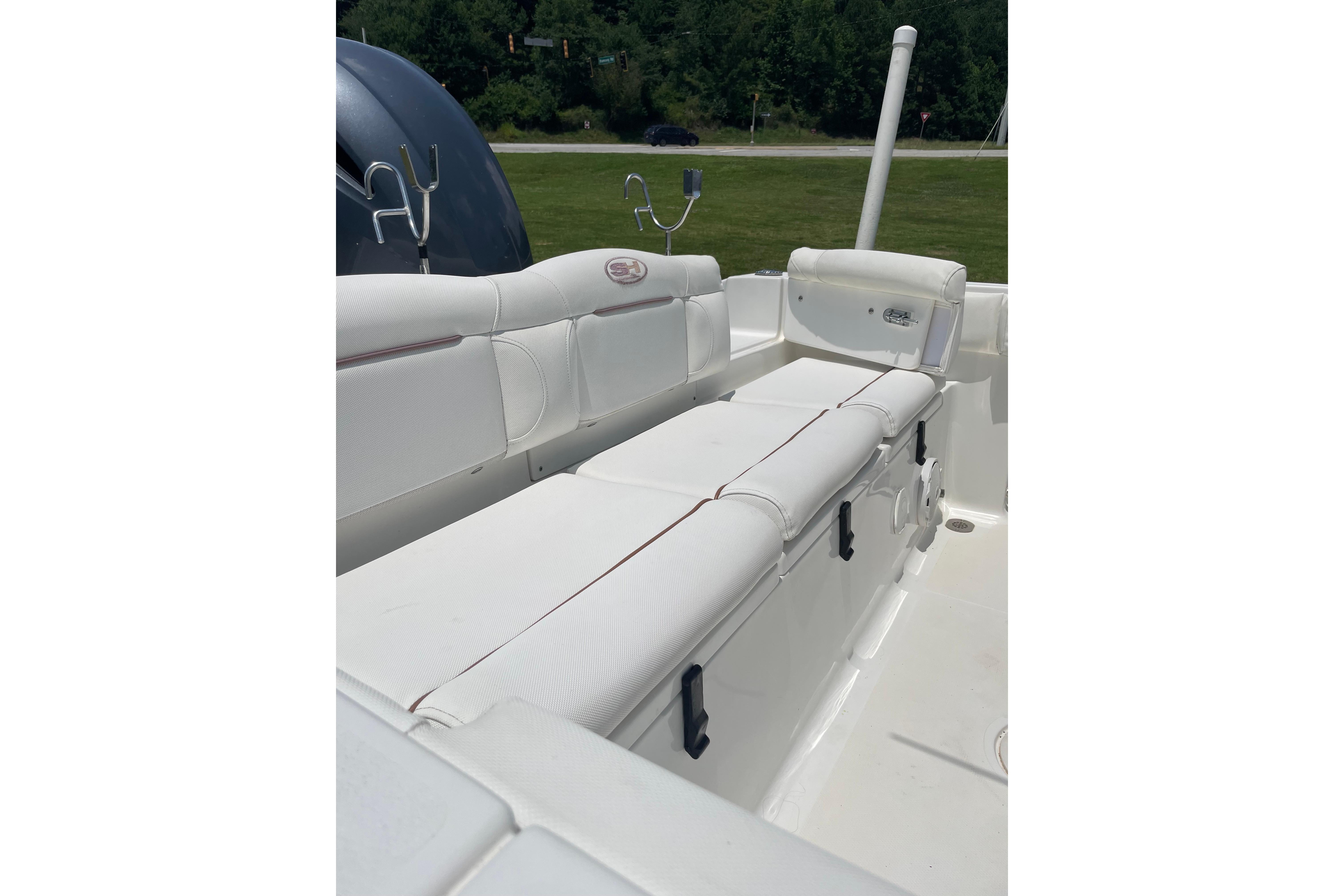 2018 Sea Hunt Ultra 234 boat interior with white cushioned seating and rod holders.