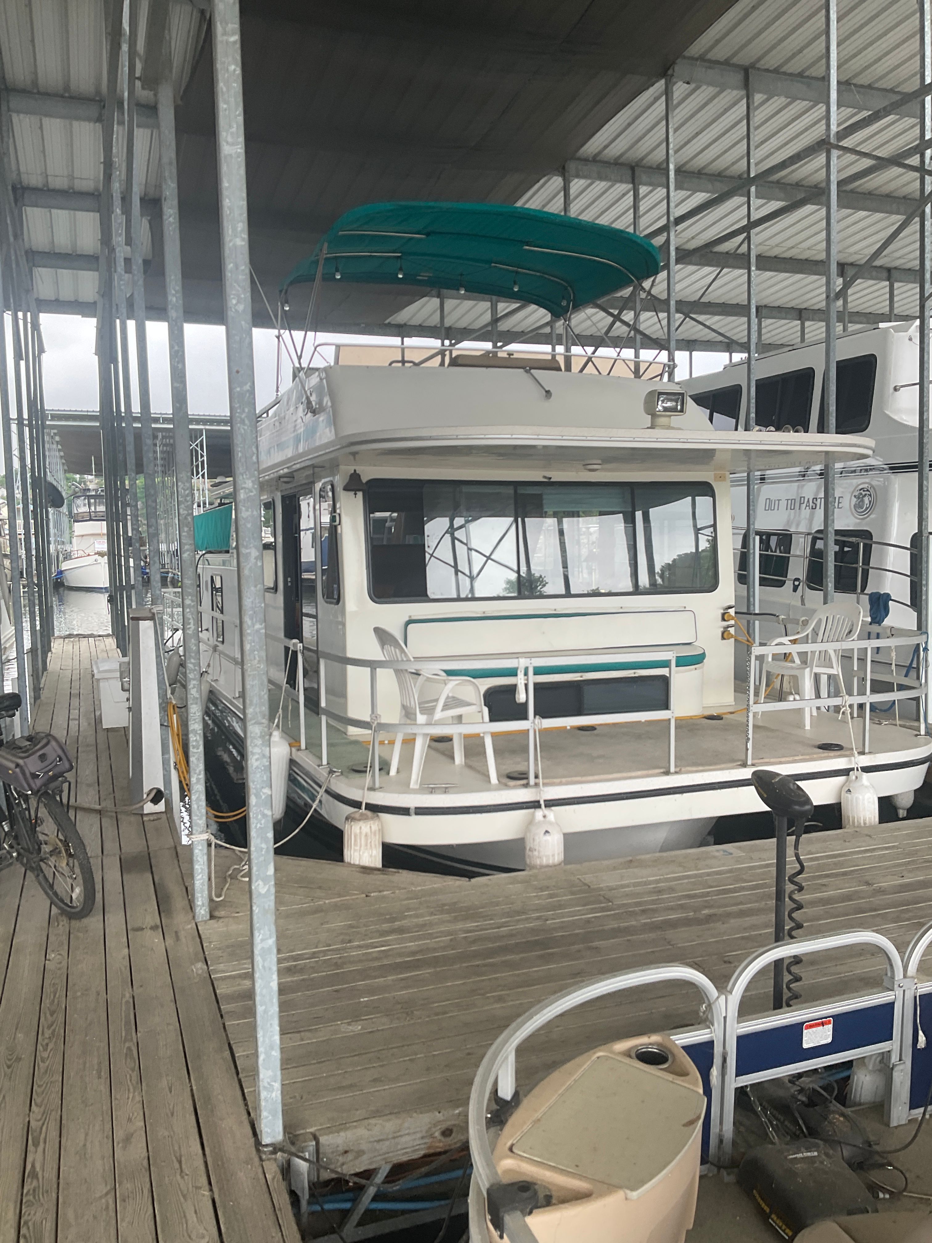 A 1996 Gibson 44 Standard houseboat docked in a covered marina.